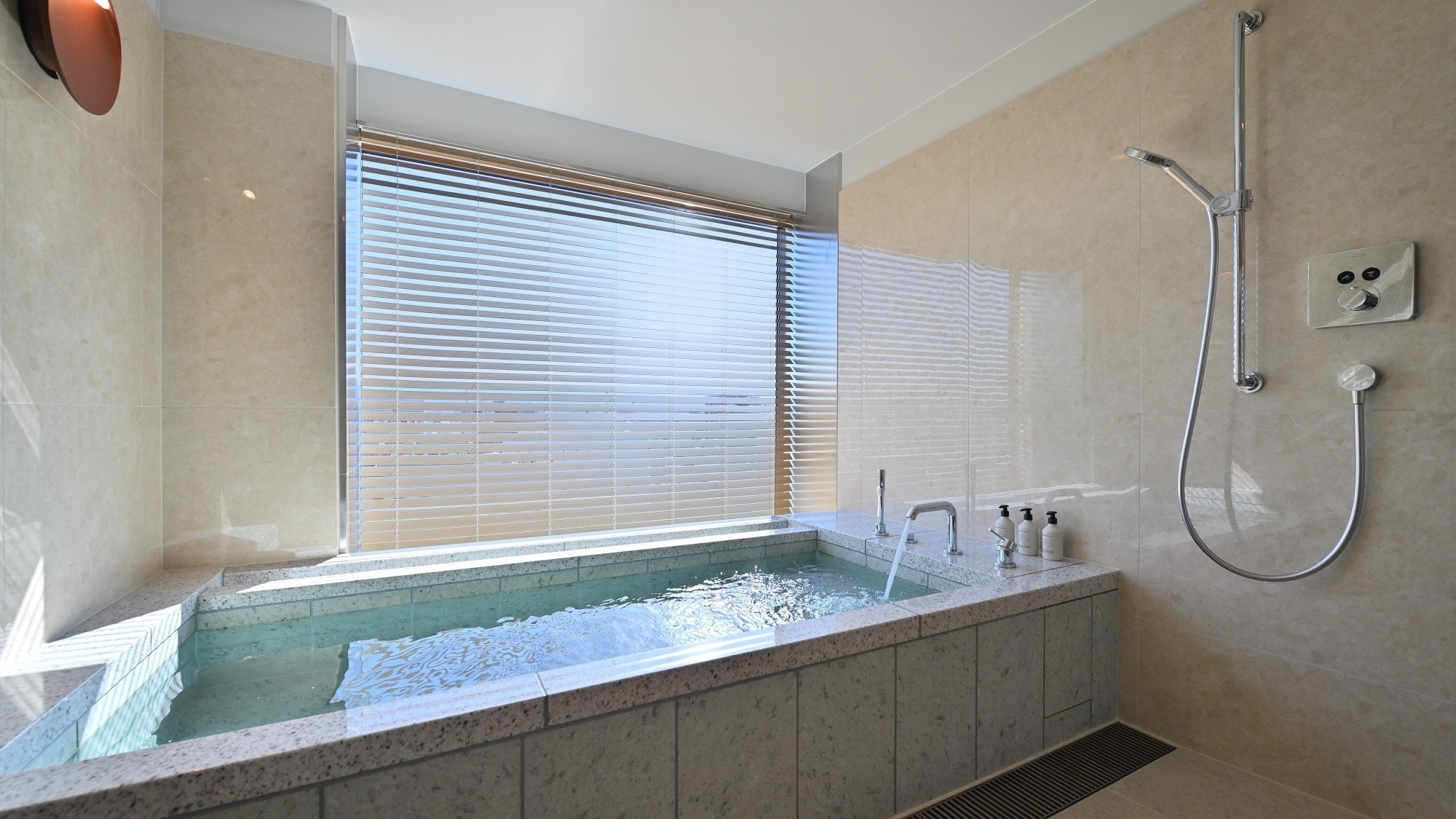 [Phòng Emperor Suite] Phòng tắm sang trọng có bồn tắm bằng đá cẩm thạch và cửa sổ lớn nhìn ra thành phố.