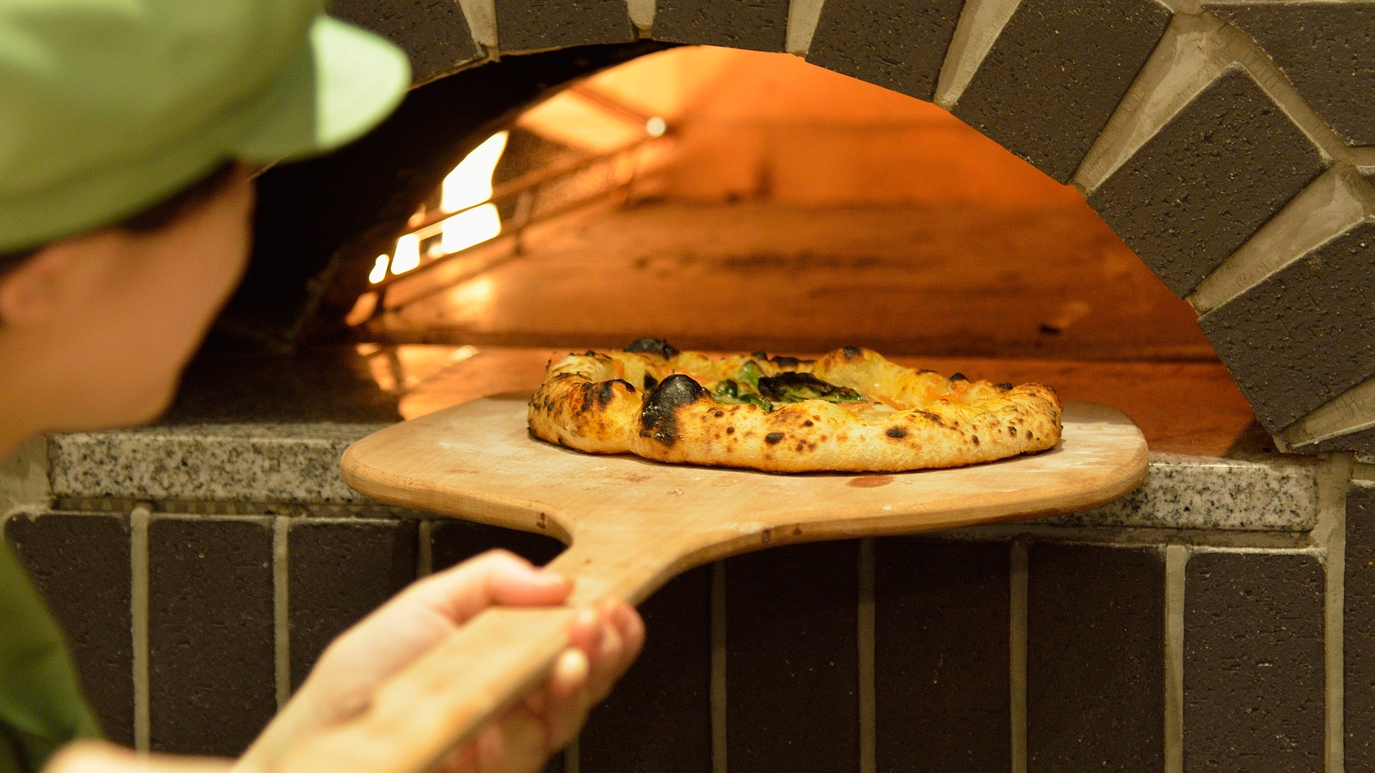 [Restaurant] Pizza baked in a full-scale stone oven.