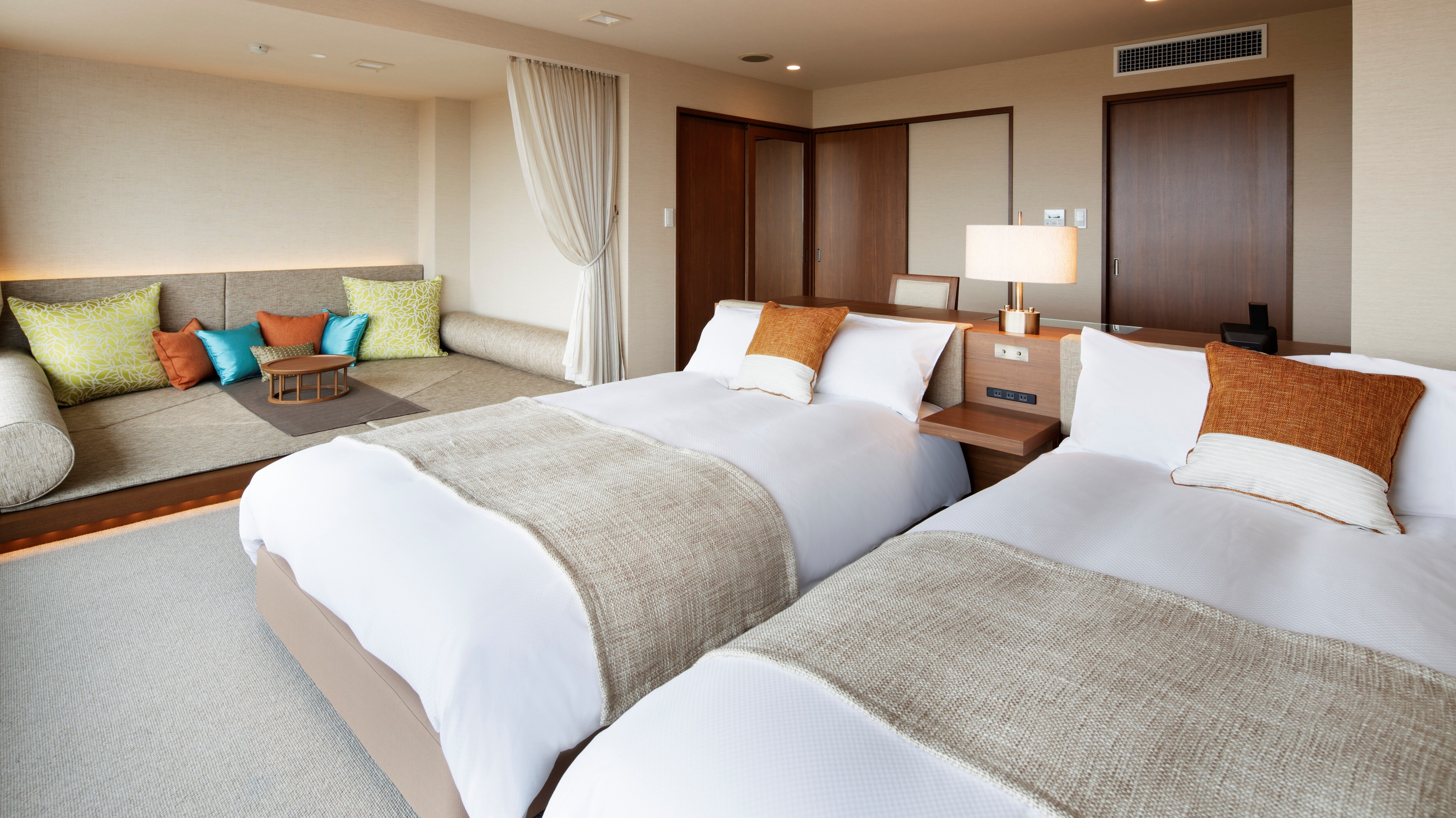 [Deluxe Room] A room with a capacity of 4 people, equipped with 2 beds and a floor sofa space.