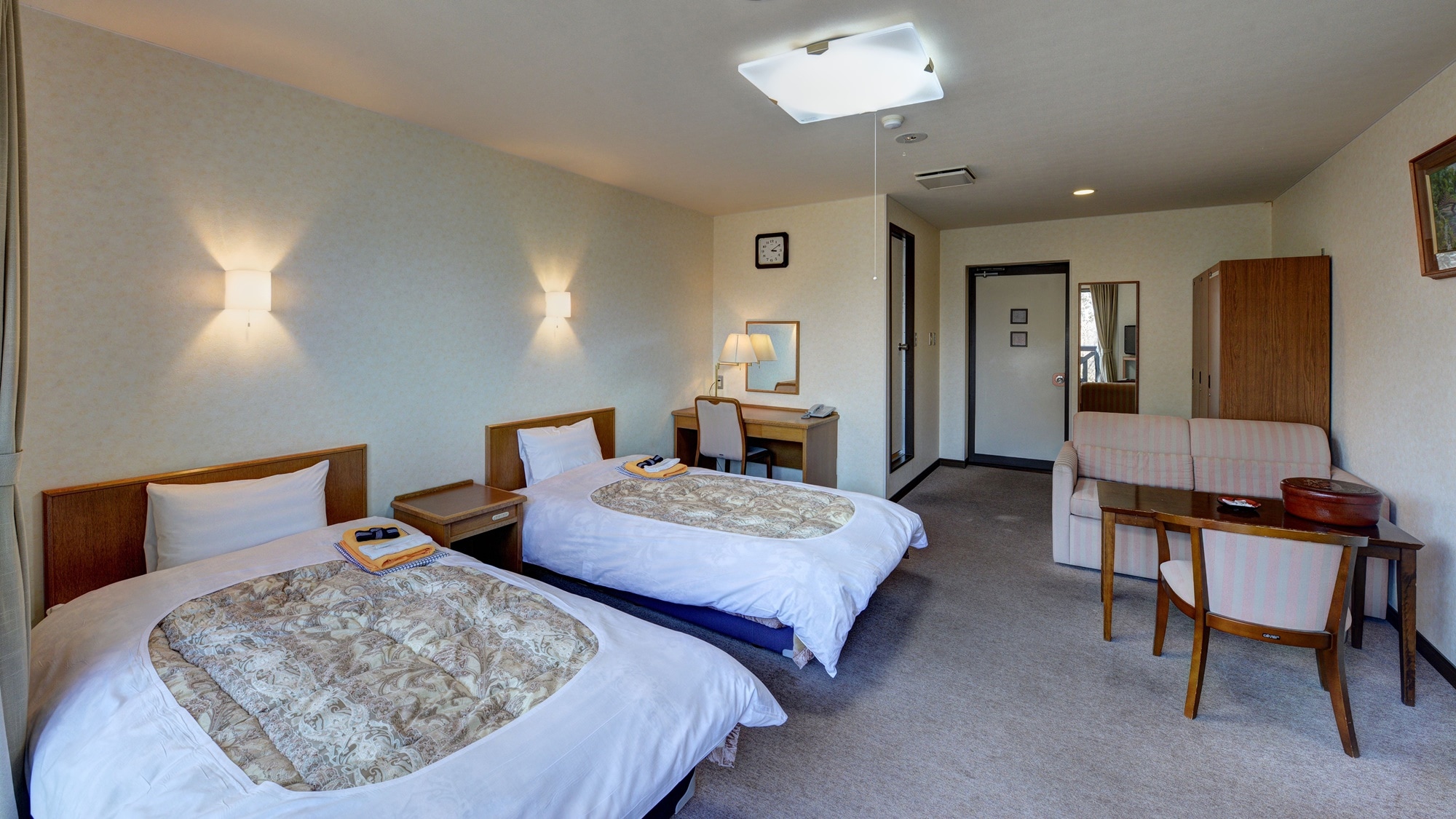 * [2nd floor twin room with unit bath] A spacious room with a desk separate from the table and sofa.