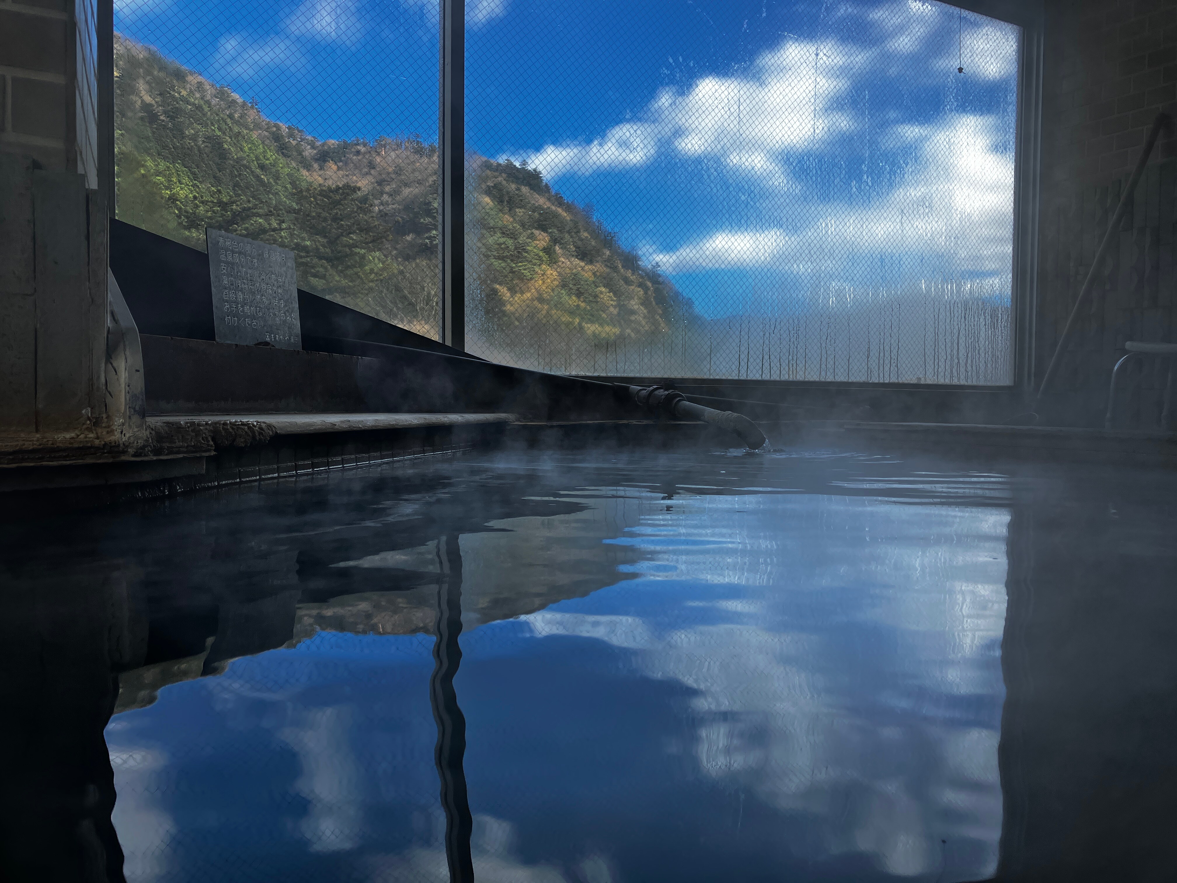 Shiobara mountains and blue sky reflected in the 7th floor observation bath
