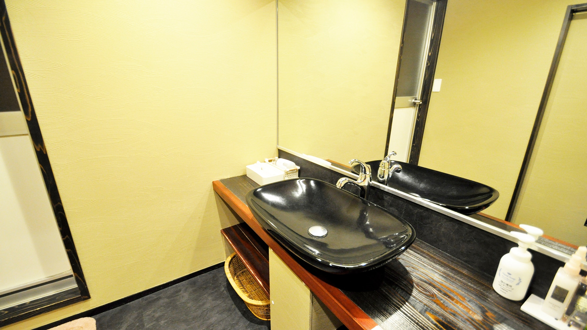 Spacious washroom with large mirror.