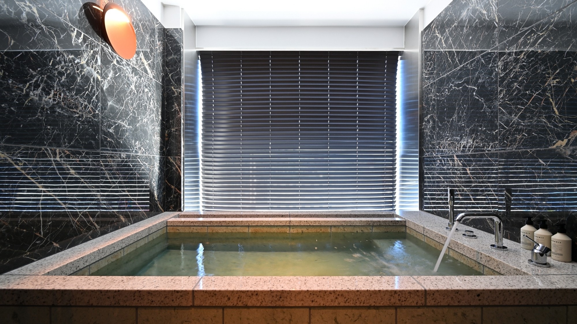[Phòng Junior Suite] Phòng tắm có cửa sổ lớn nhìn ra quang cảnh thành phố. Bồn tắm rộng rãi được làm bằng đá cẩm thạch.