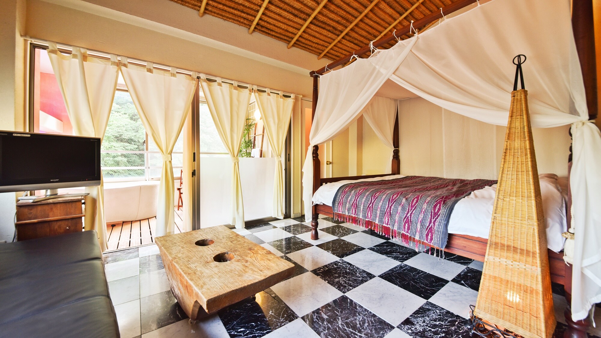 * [White Nights] The alang-alang style ceiling and canopy bed create the atmosphere of a Balinese resort.