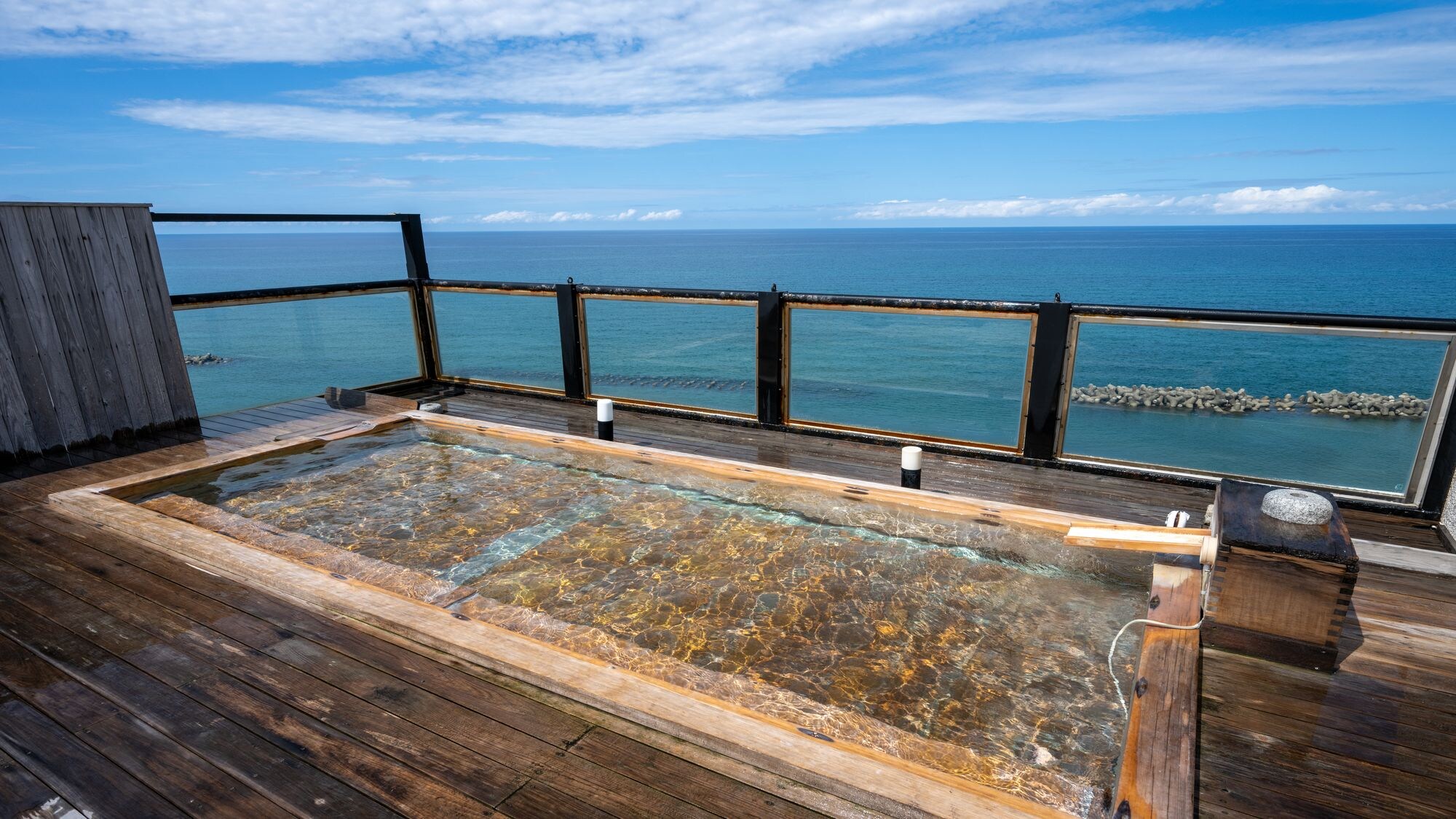 [Open-air bath with a view] An open-air bath with a view of the blue sky and the sea below.