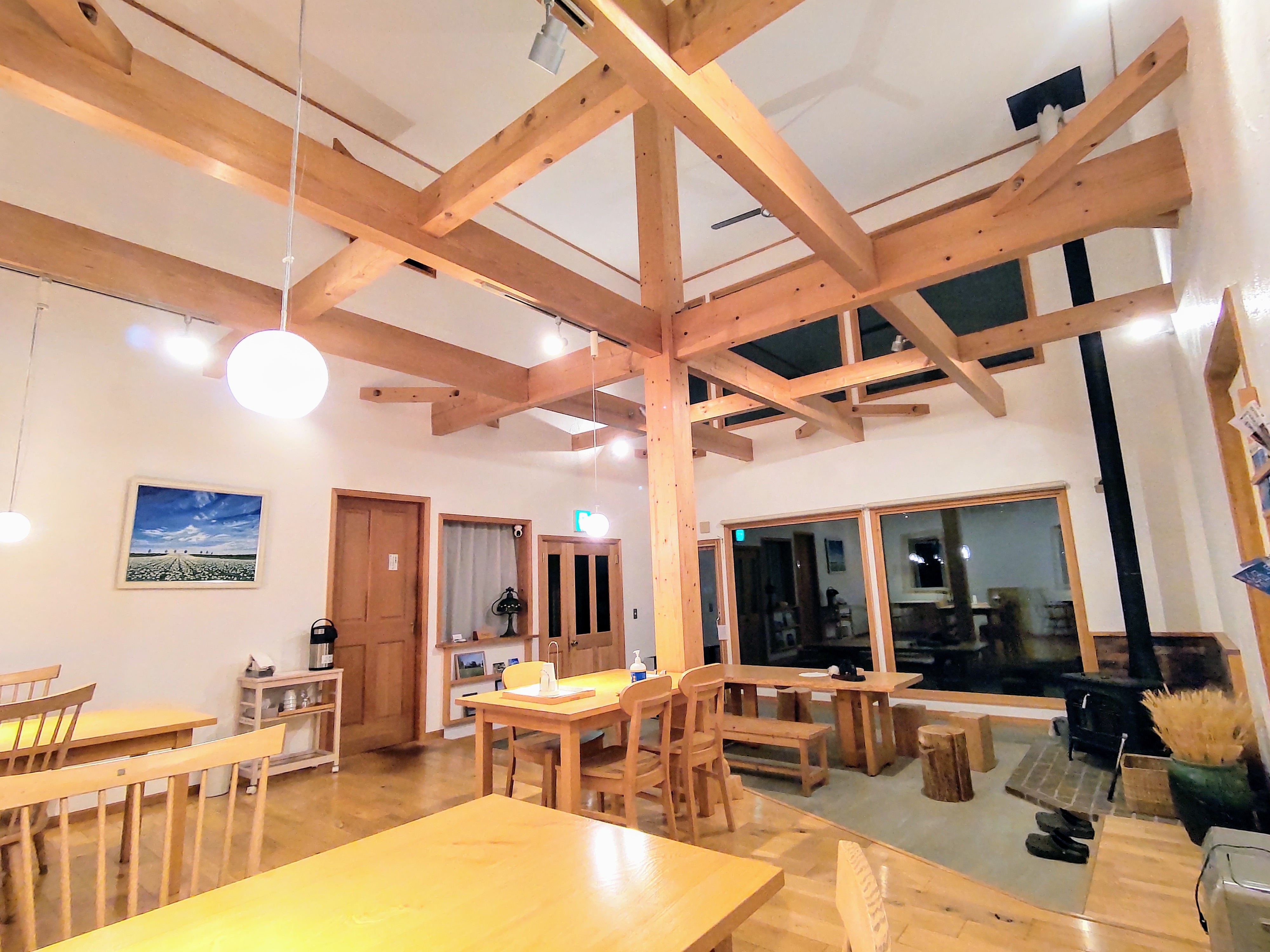Dining room: high ceiling, plaster walls, wood stove flames, delicious locally produced food
