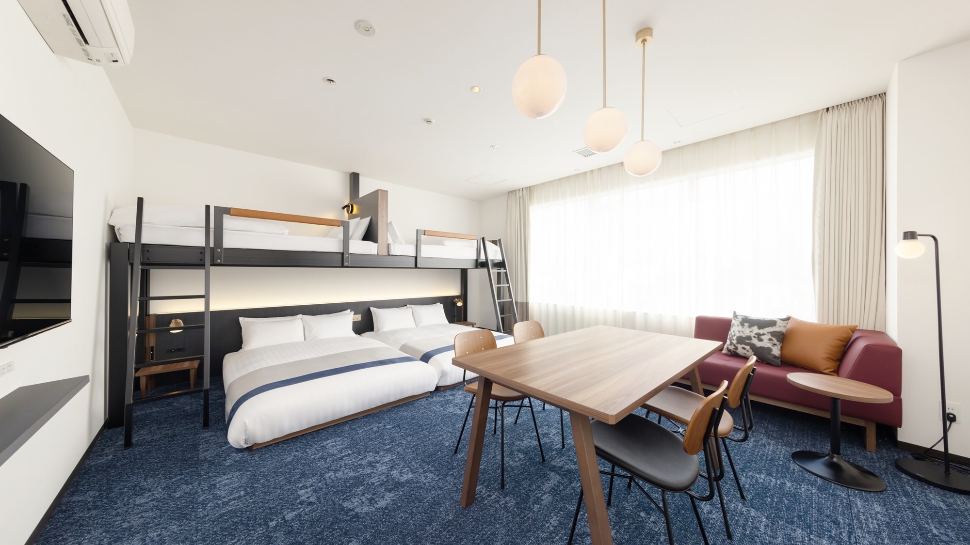 [Deluxe Family Takumi] A workshop-like room with a studded sofa and denim-style carpet.