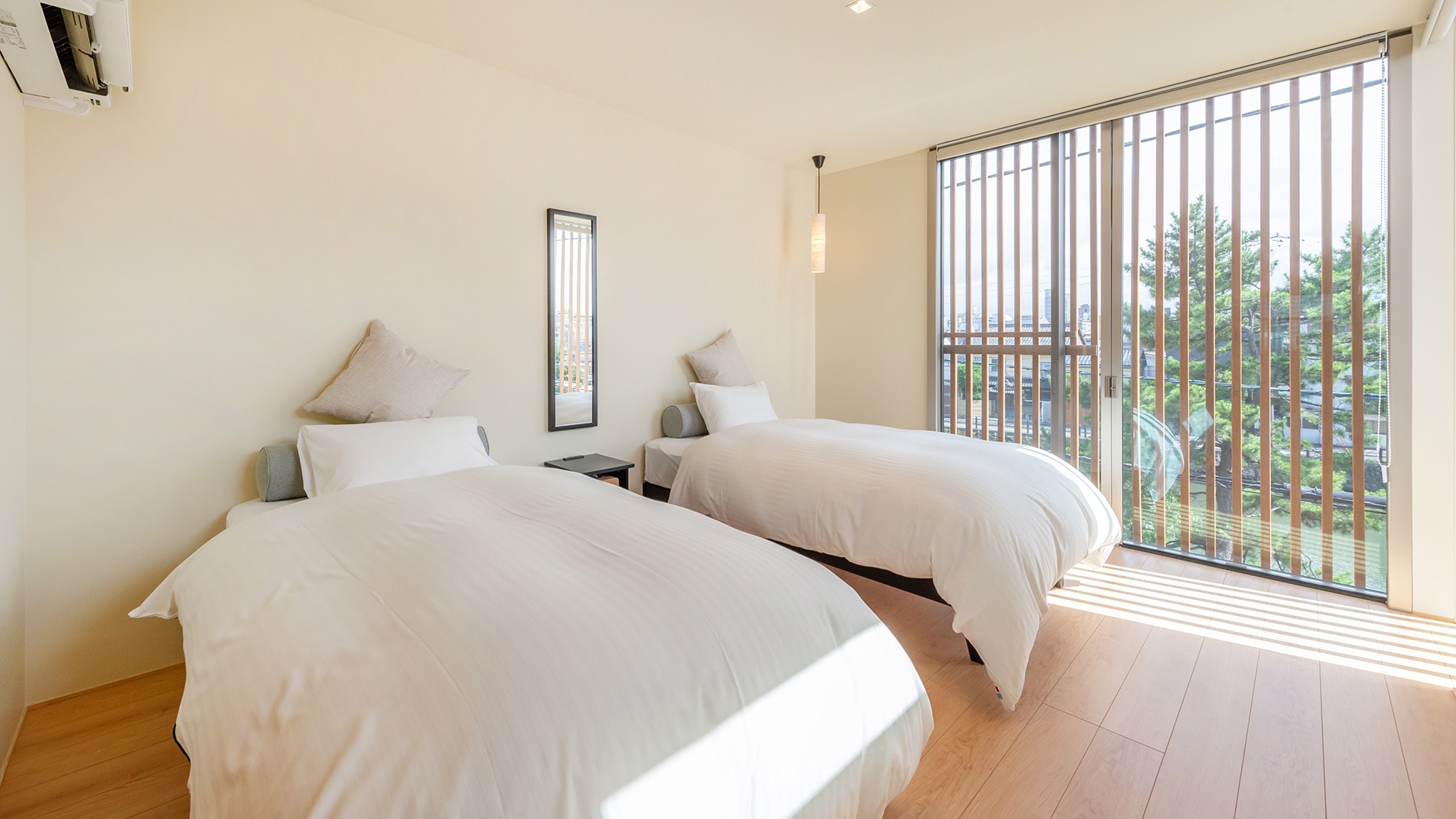 ・[Bedroom A] Warm light pours in through the large windows.
