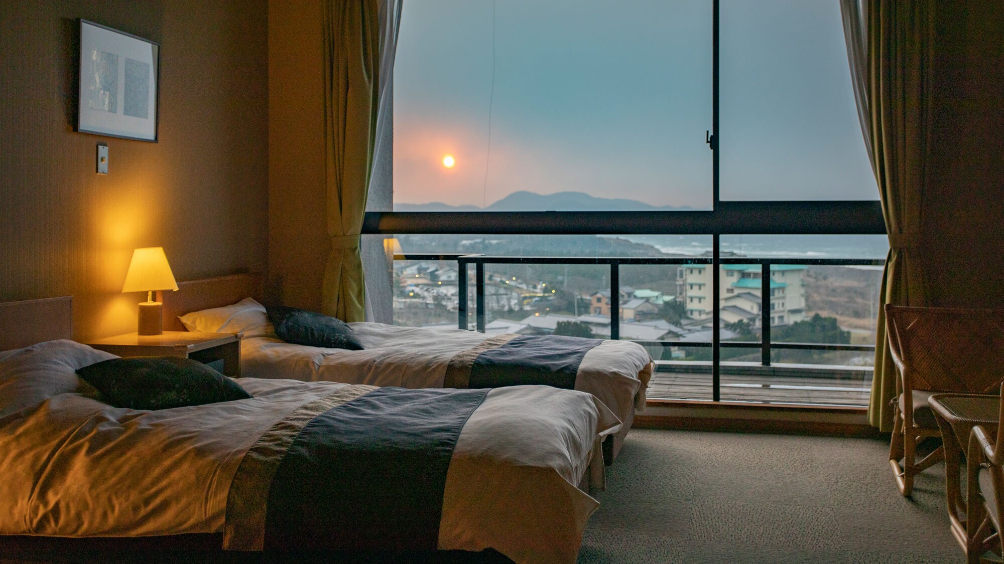 一盞微弱的燈和夕陽。 Kasyouen 酒店的所有客房都享有大海的全景。