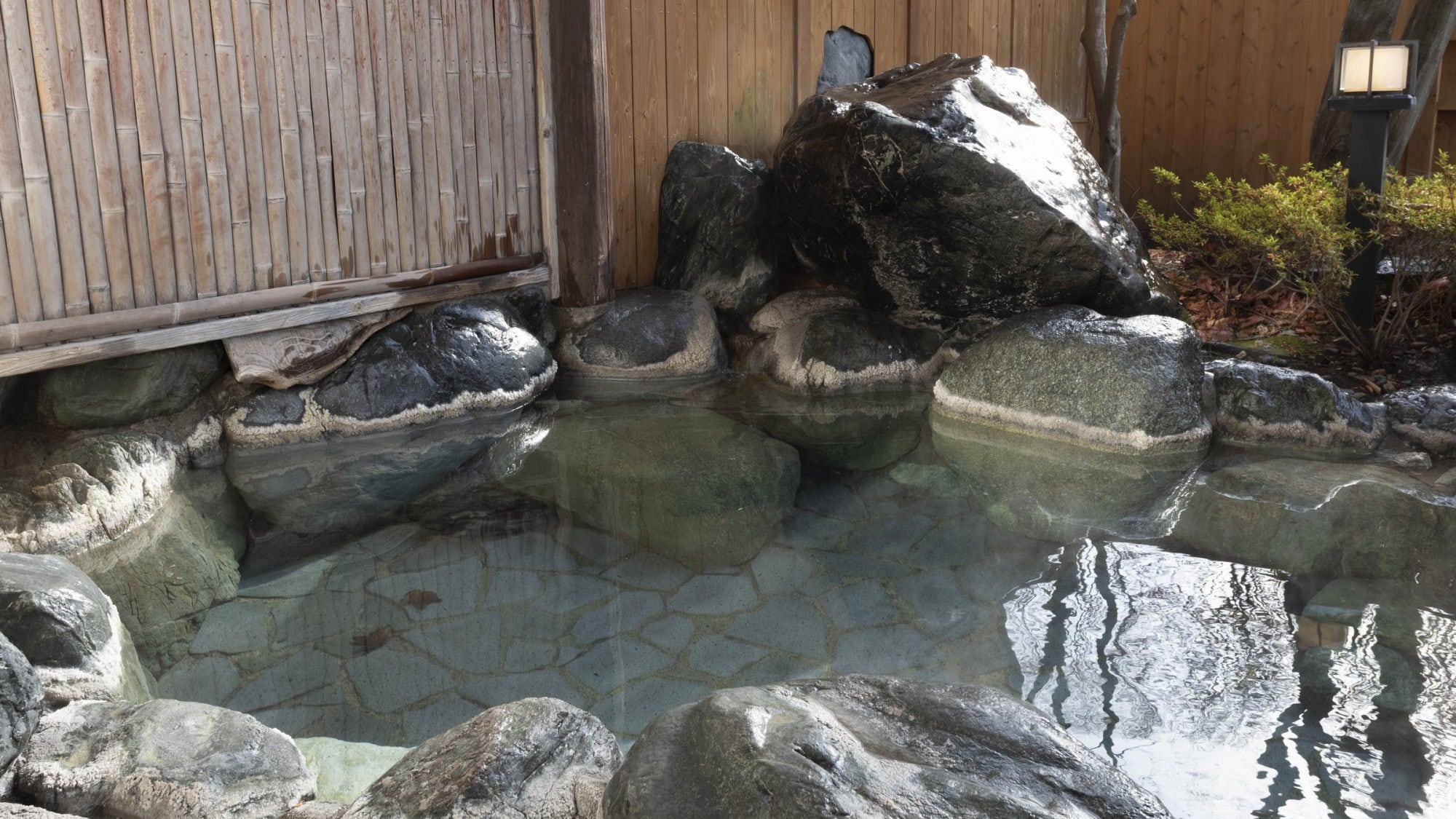 [Open-air bath for men] The owner of the inn piled up huge stones cut from the miraculous Mount Omine himself to create an open-air rock bath on top of a stone wall.