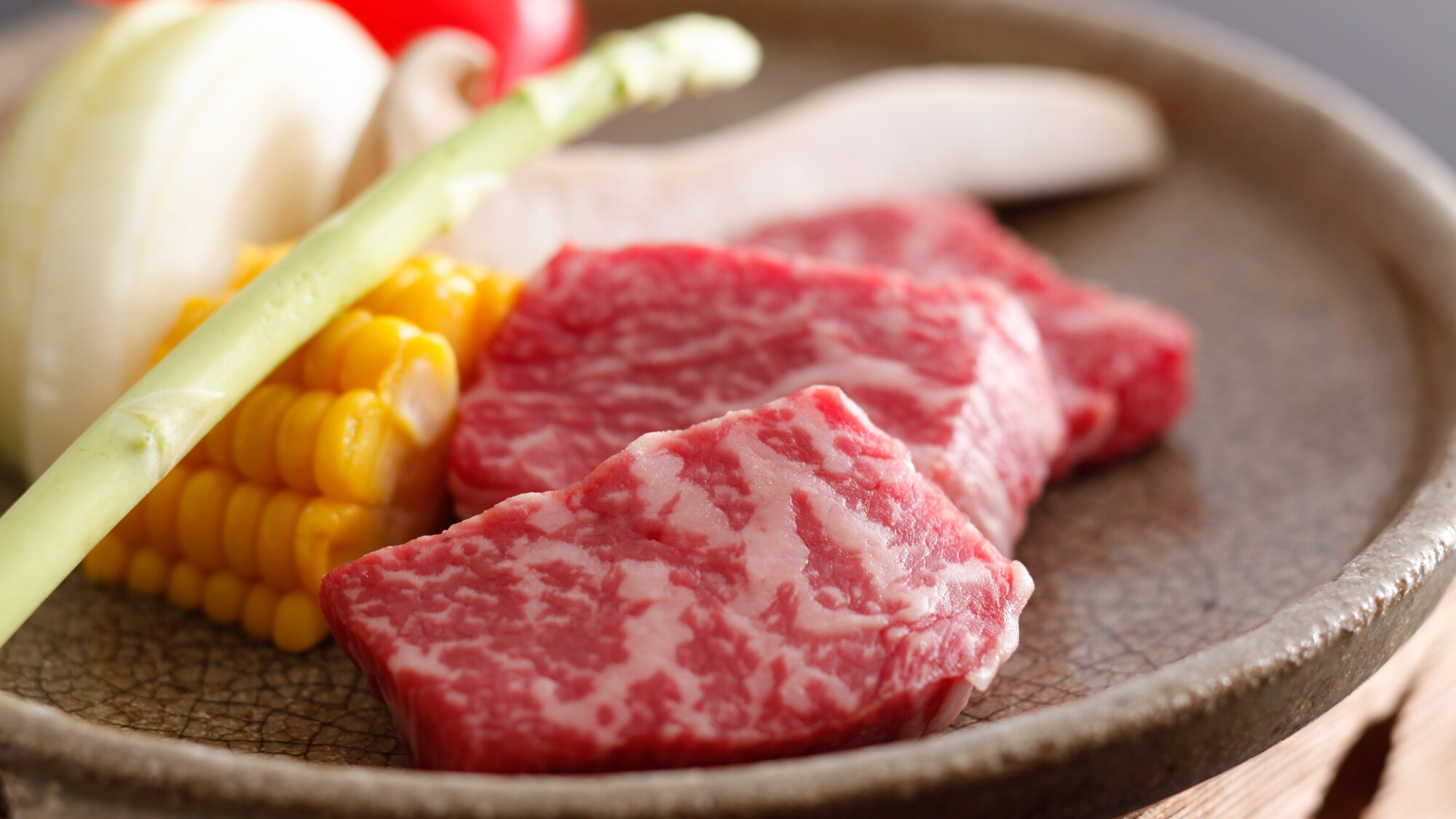 High-quality Awaji beef and local vegetables including Awaji onions, grilled on a ceramic plate (image of dish)