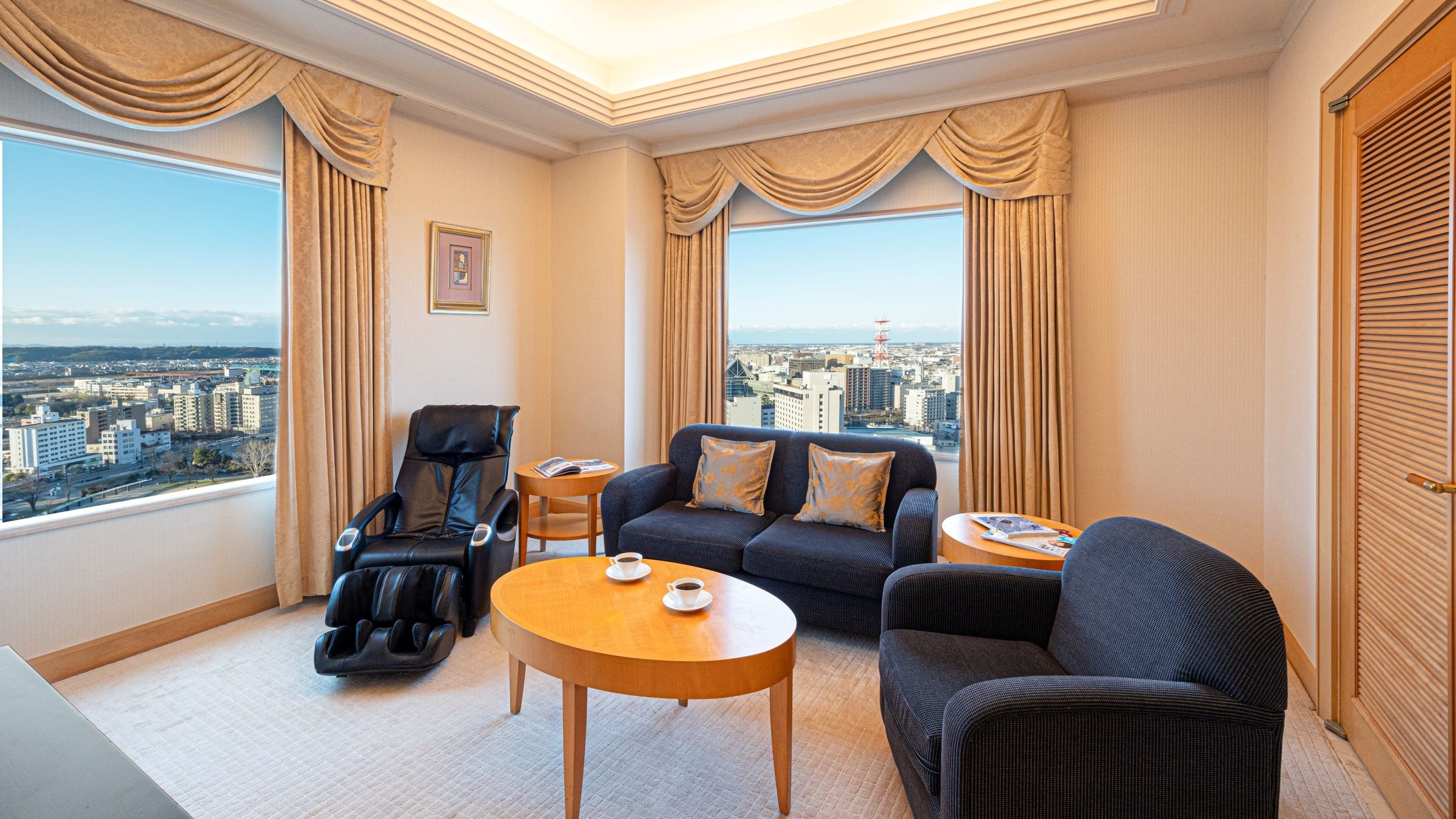 이그제큐티브 스위트의 거실 2면 있는 창문으로 객실에서 도야마의 거리를 즐길 수 있습니다.
