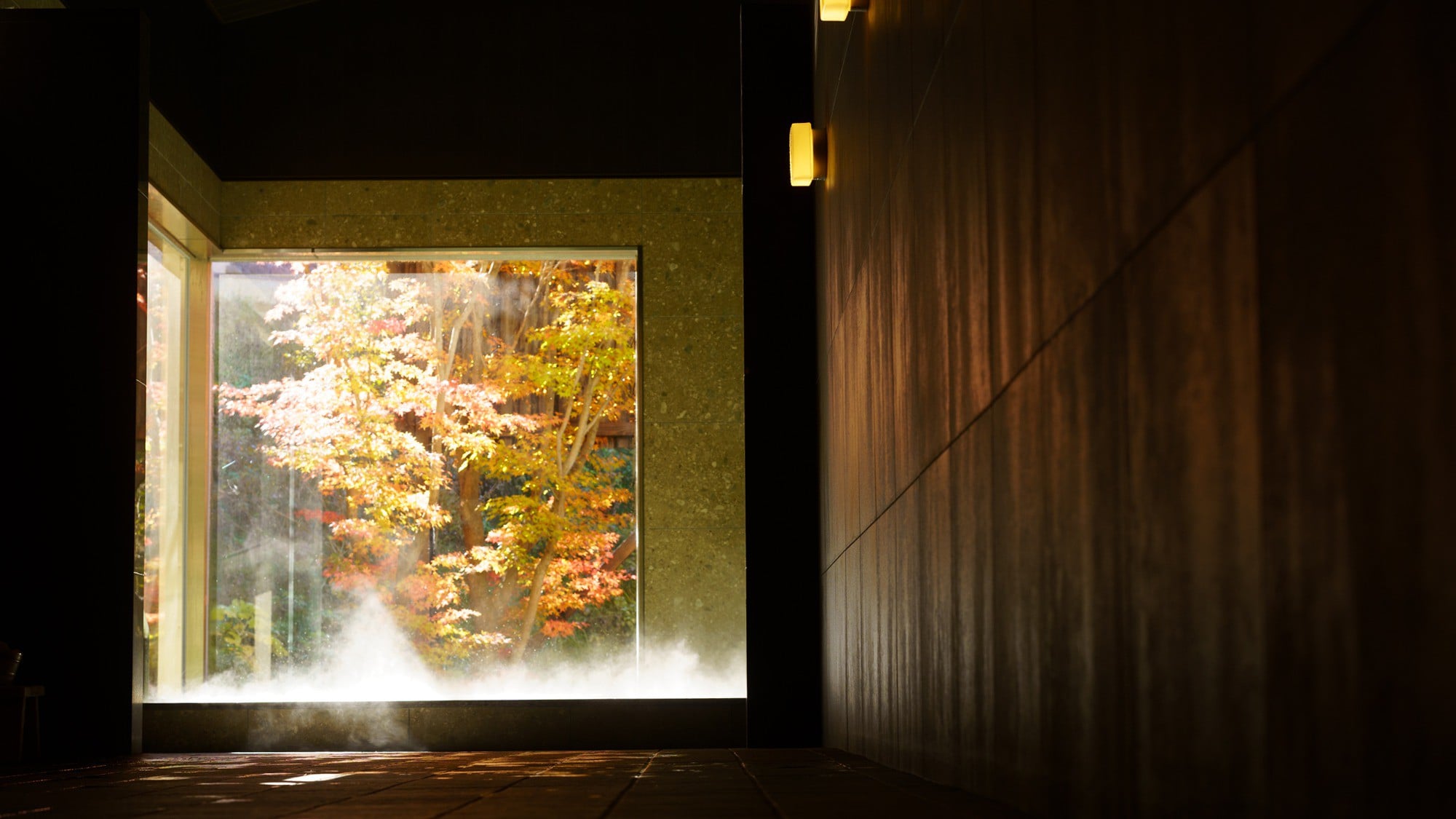 Day trip hot spring (free for overnight guests) / Autumn leaves at Happu Onsen / Beyond the door, the vibrant autumn leaves shine through the open glass windows