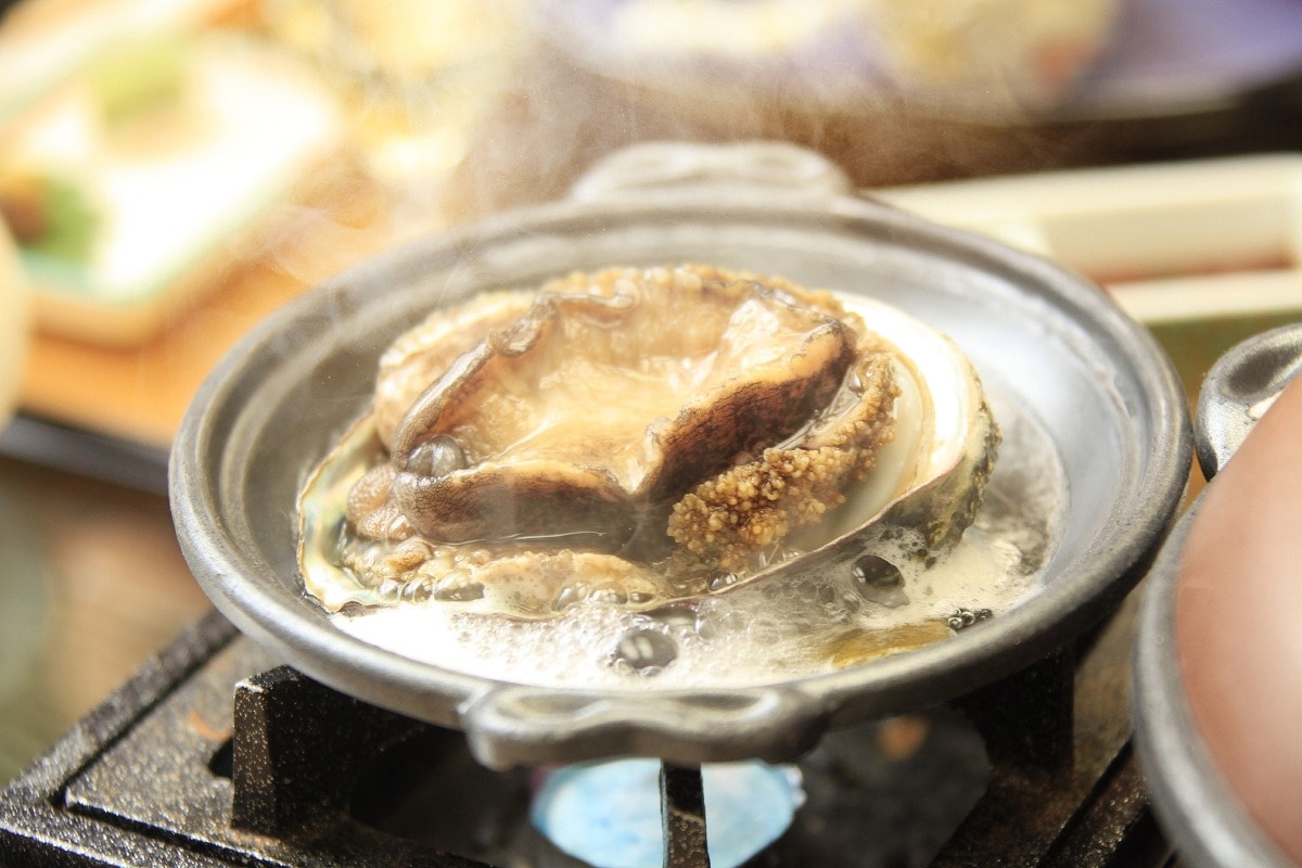 The main dish of the Ryokusui Gozen plan is "Steamed live abalone in sake"