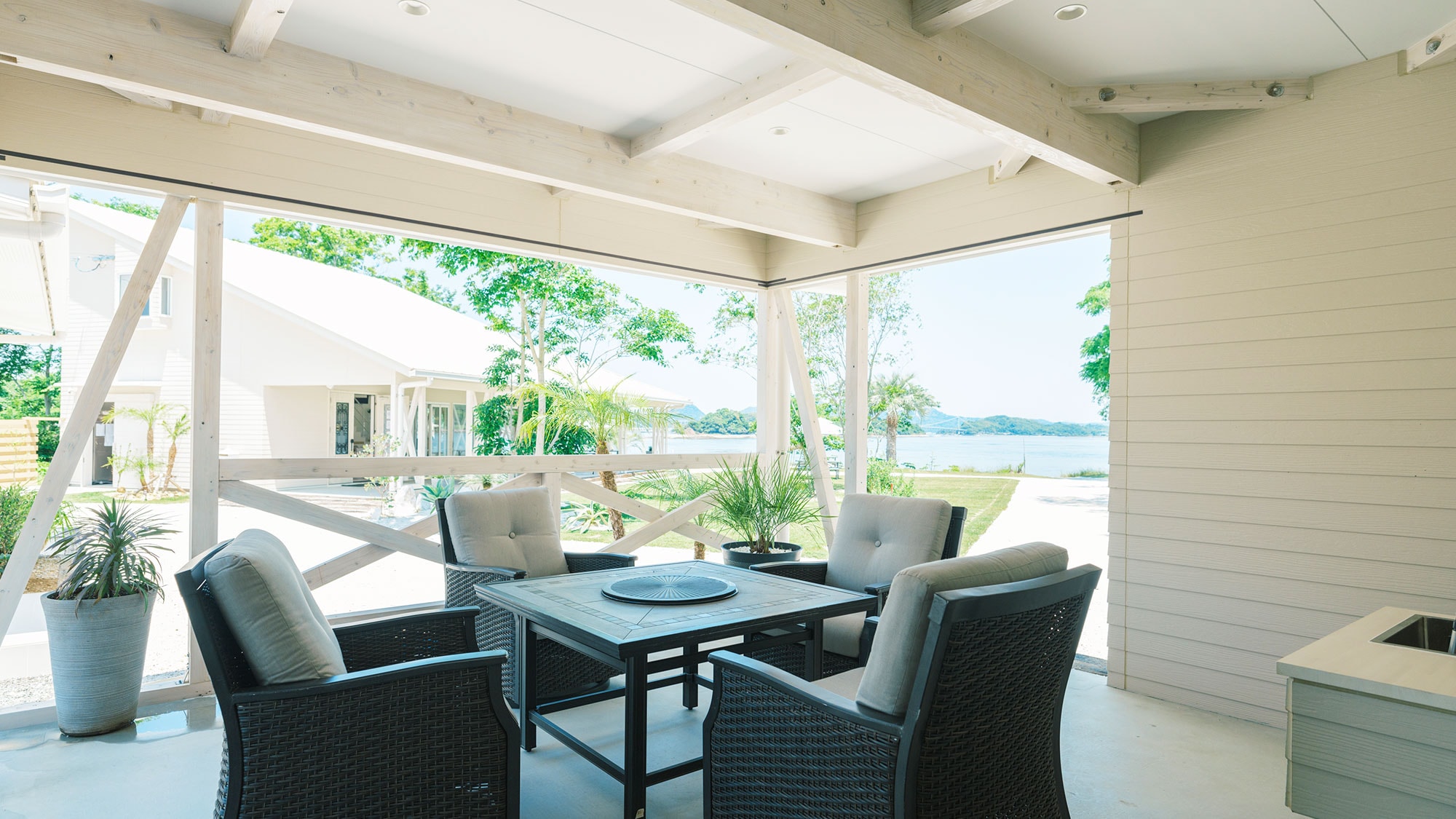 [Villa B / 72.04 m2] The spacious terrace connected by a large window is a relaxing space where you can look out at the sea.