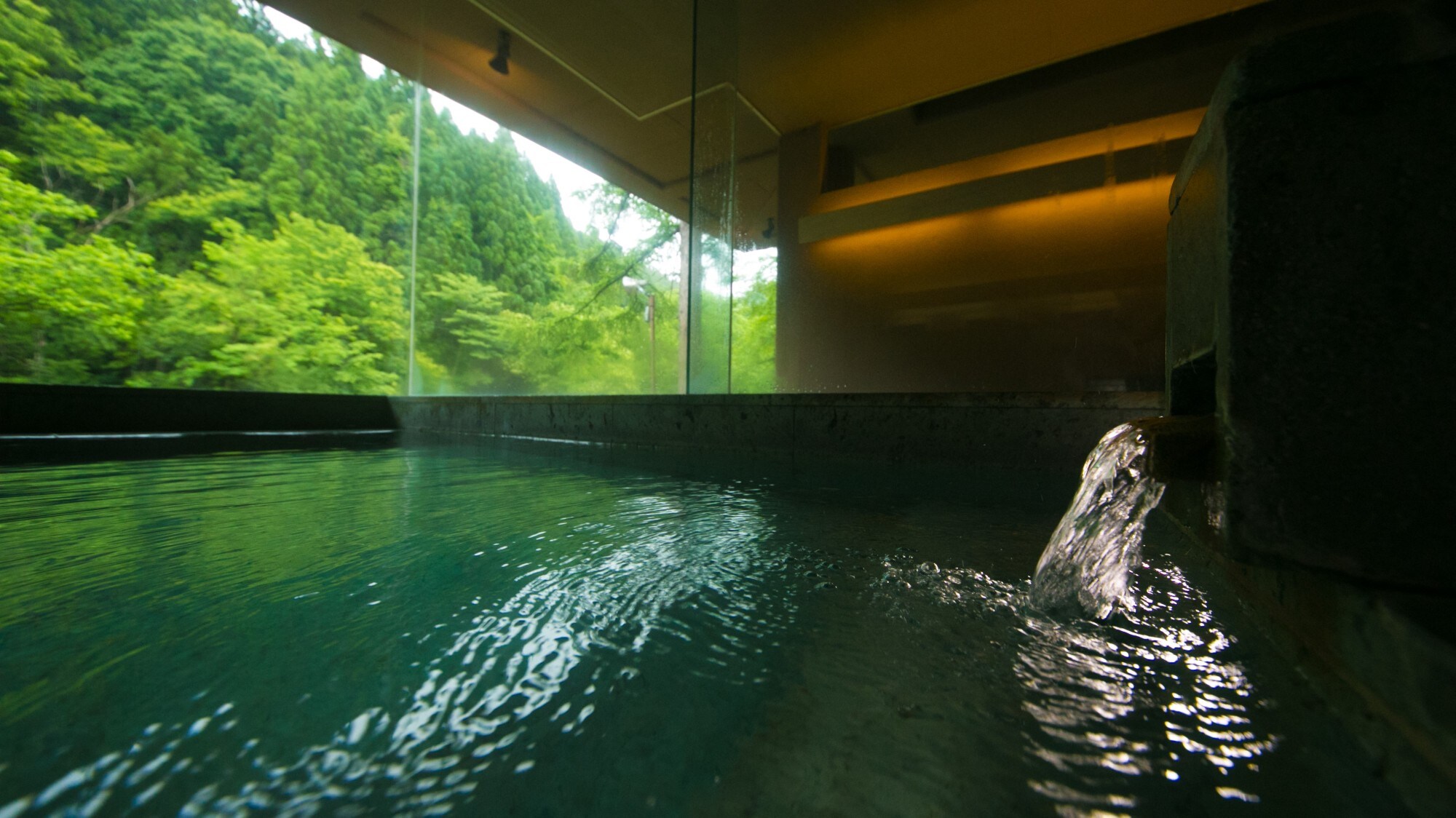 [Indoor bath with open-air bath / Time and Light Bath] From the large window facing the mountain stream, you can enjoy the changing nature of the seasons.