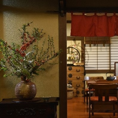 Flower arrangements next to the front desk and a hearth cafe at the back