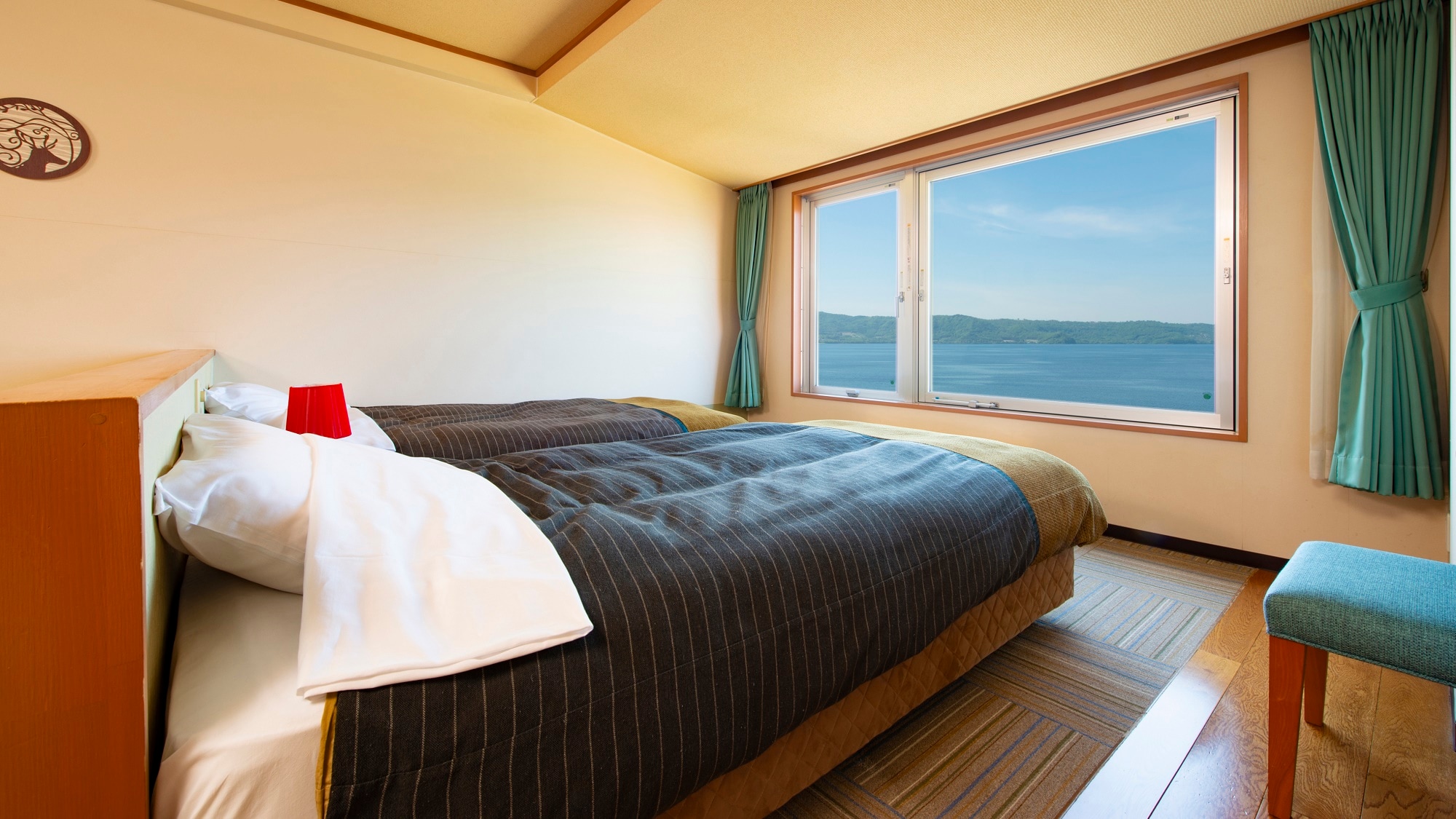 [West Building / Japanese / Western Room] Two types of rooms are available: a room with a bed on the windowsill overlooking Lake Toya and a room with a tatami mat space.