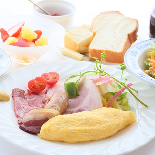 ・A fluffy omelette, homemade bread, and sausage breakfast
