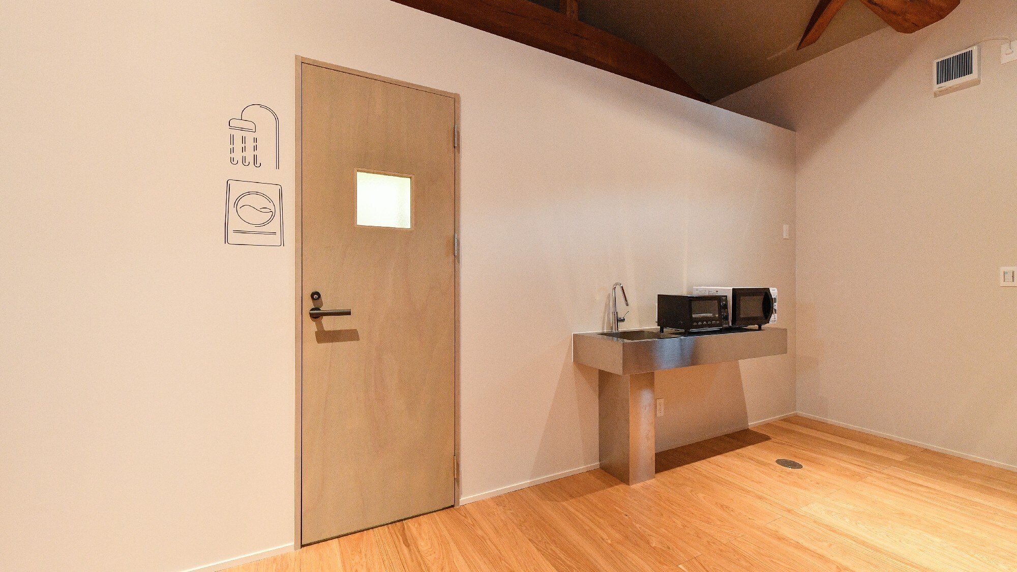 Accommodation area, shower booth entrance, microwave and toaster corner