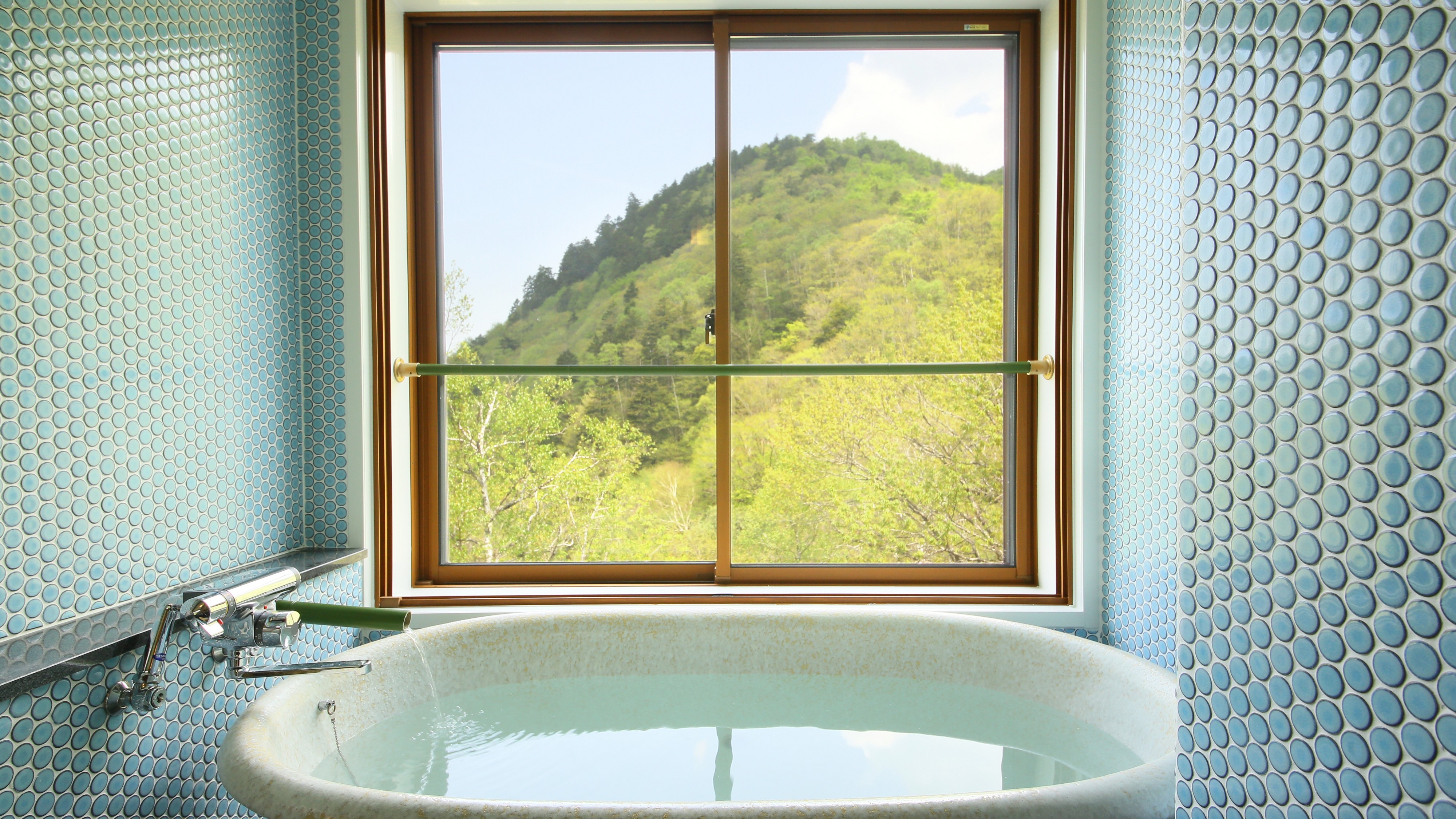 A hot spring bath in a modern Japanese style guest room. Enjoy the beautiful scenery while enjoying the white hot springs. cute retro tiles