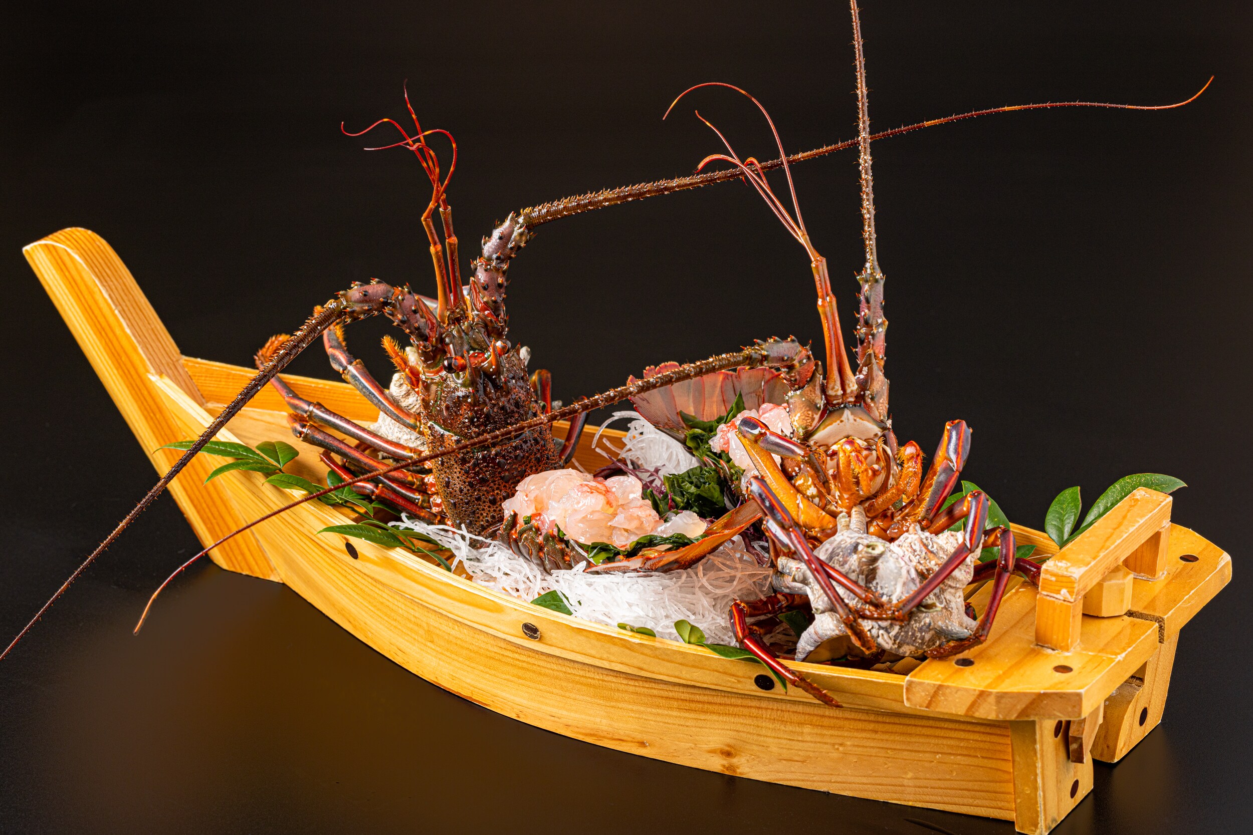 Whole lobster sashimi served on a boat