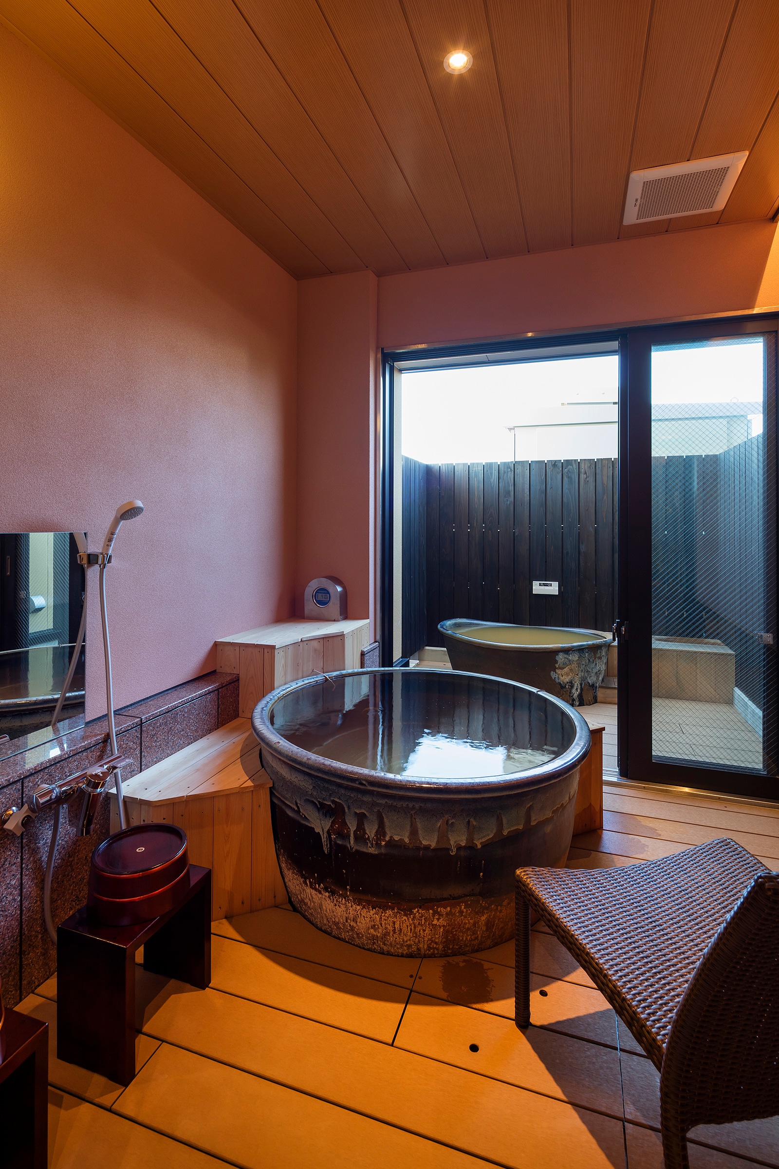 Open-air bath in guest room with bed Photo by Yasunori Shimomura