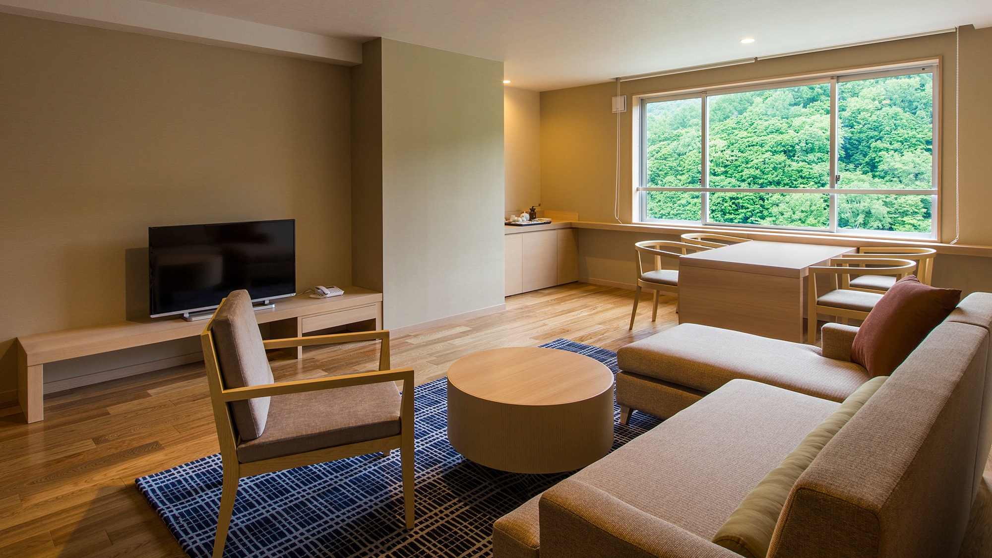 [Women's Premium] There is also a large sofa in the living space and a table set by the window.