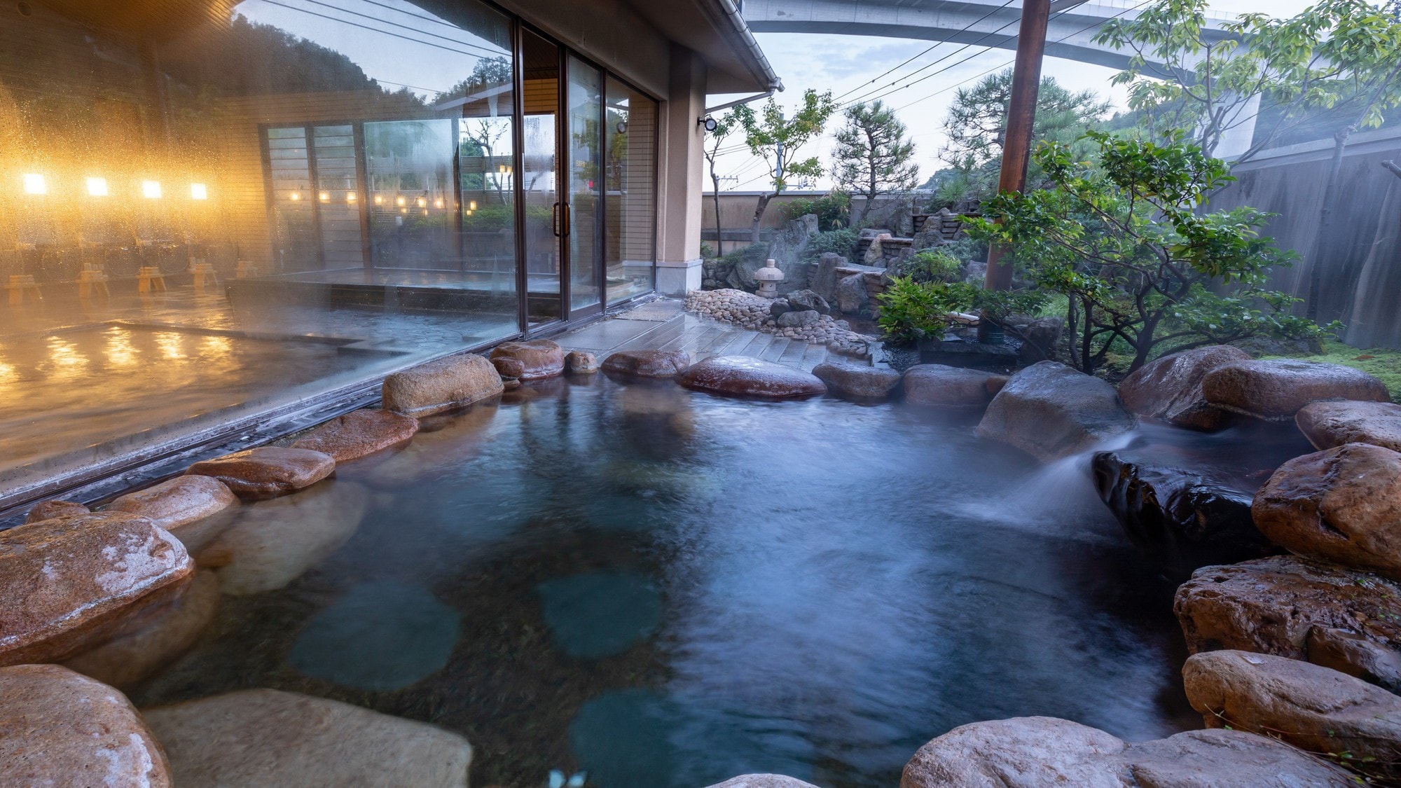 [Large public bath open-air bath (male)] You can see the distant sky while soaking in the bathtub of the open-air bath.