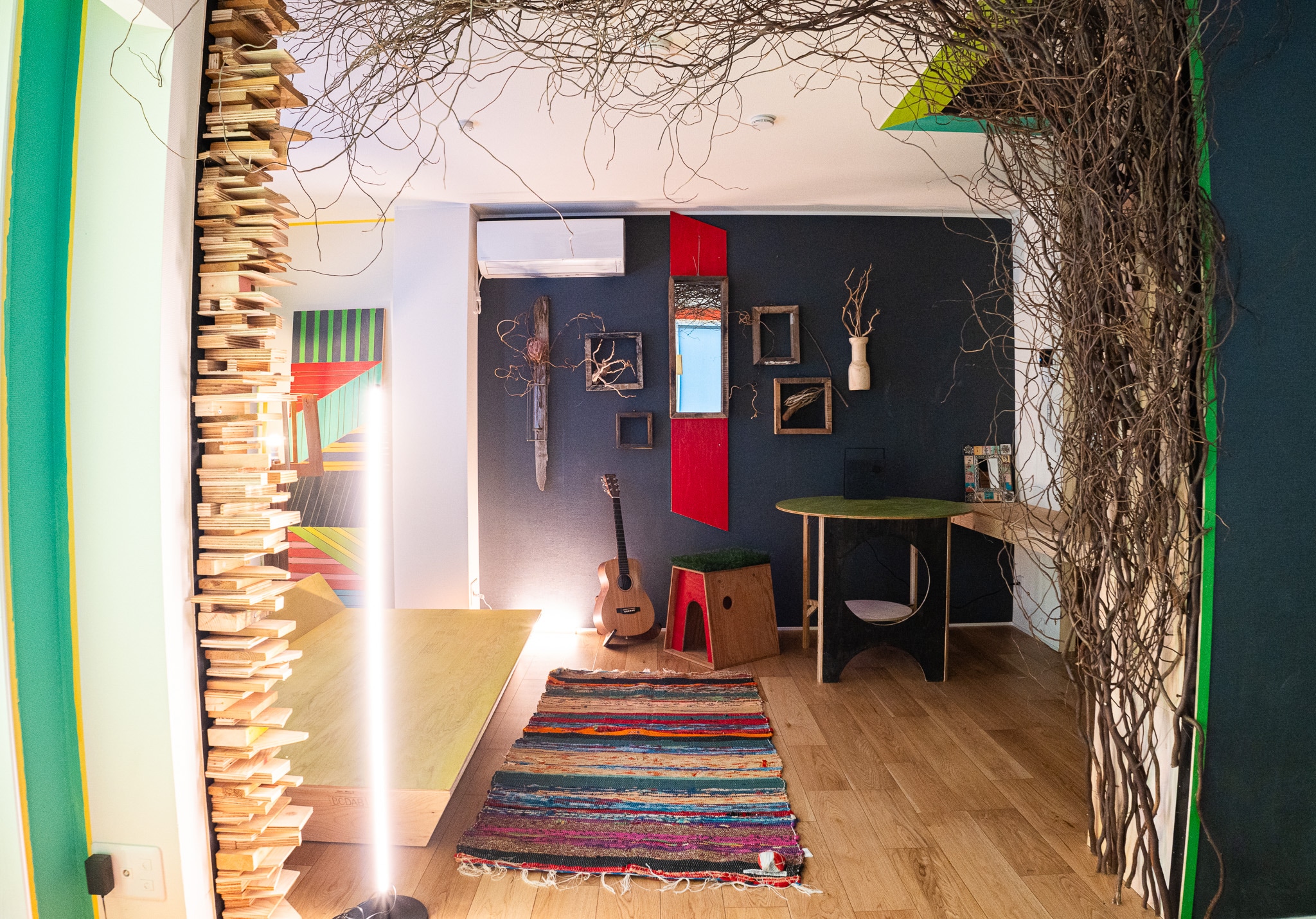 Art and mirrors cover an entire wall at the back of the tunnel of trees. A popular space for women to relax while listening to records.