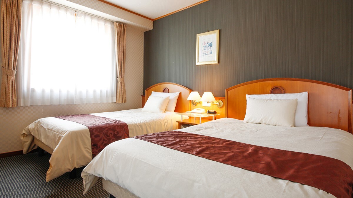 Phòng góc rộng 37,1㎡ này có hai cửa sổ lớn, được trang bị một giường đôi và một giường bán đôi.