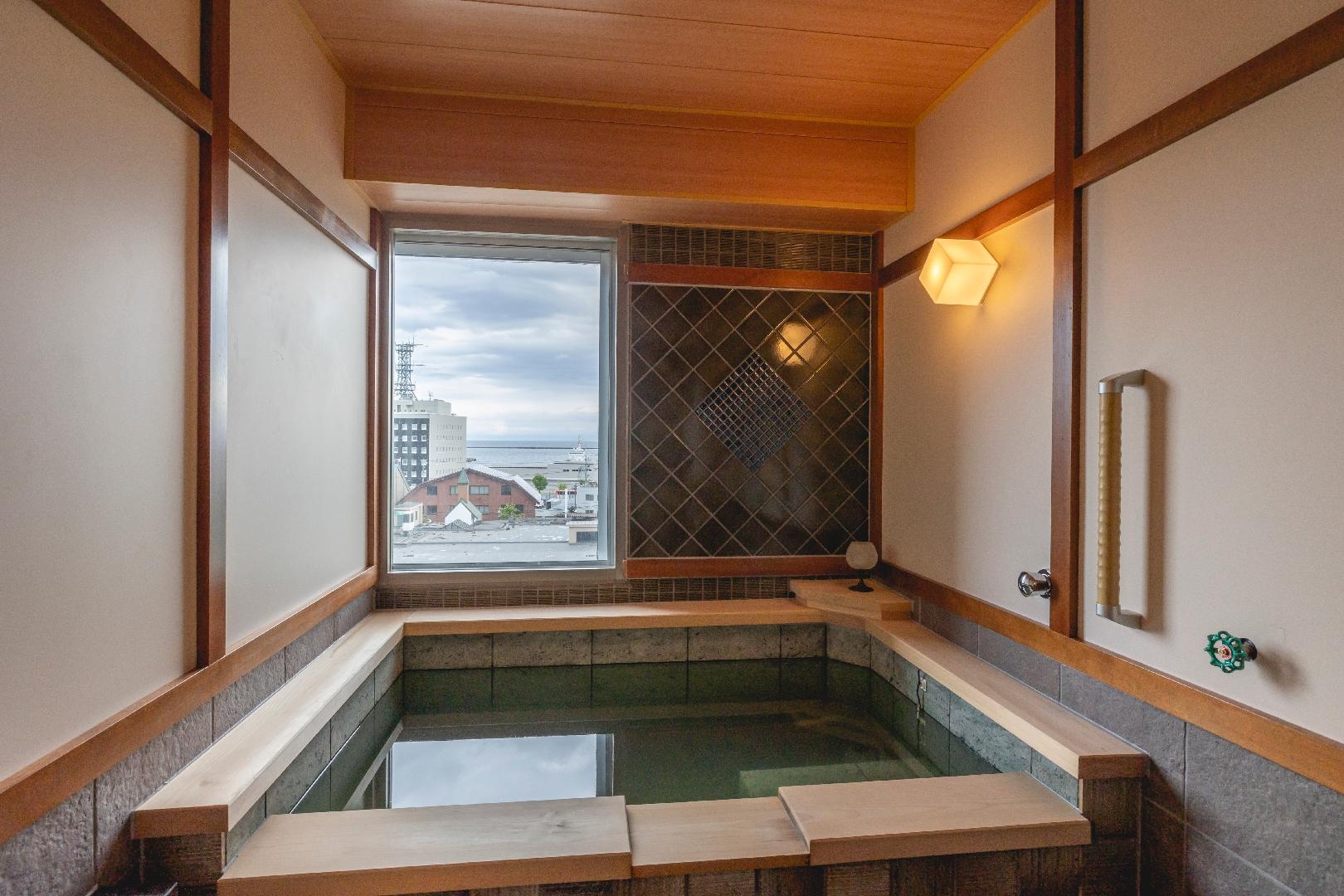 Kamar mandi tamu kamar premium dengan sumber air panas di sisi kanal