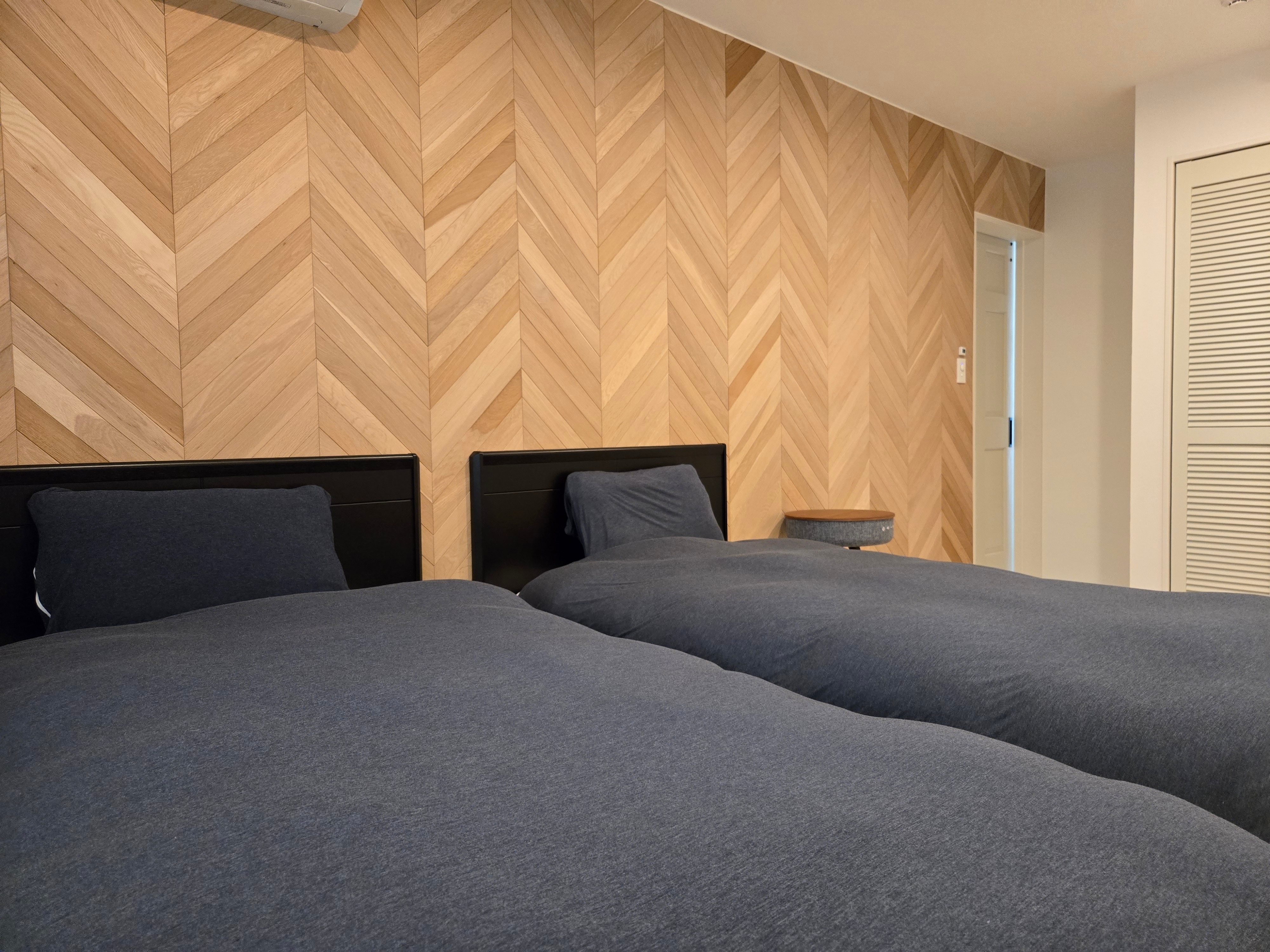 A calm bedroom with a wood accent wall.