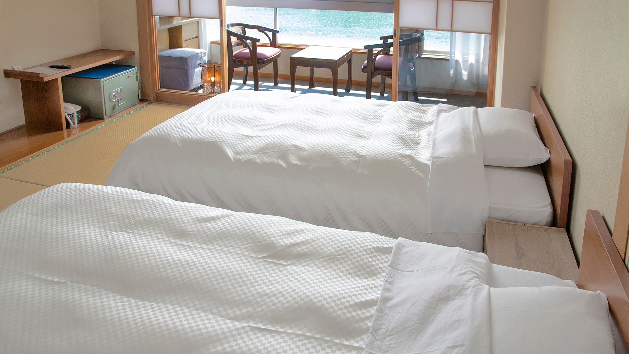 A bed-type Japanese-style room on the top floor. The view is very good, and you can see the port of Yobuko and the Yobuko Ohashi Bridge in the distance.