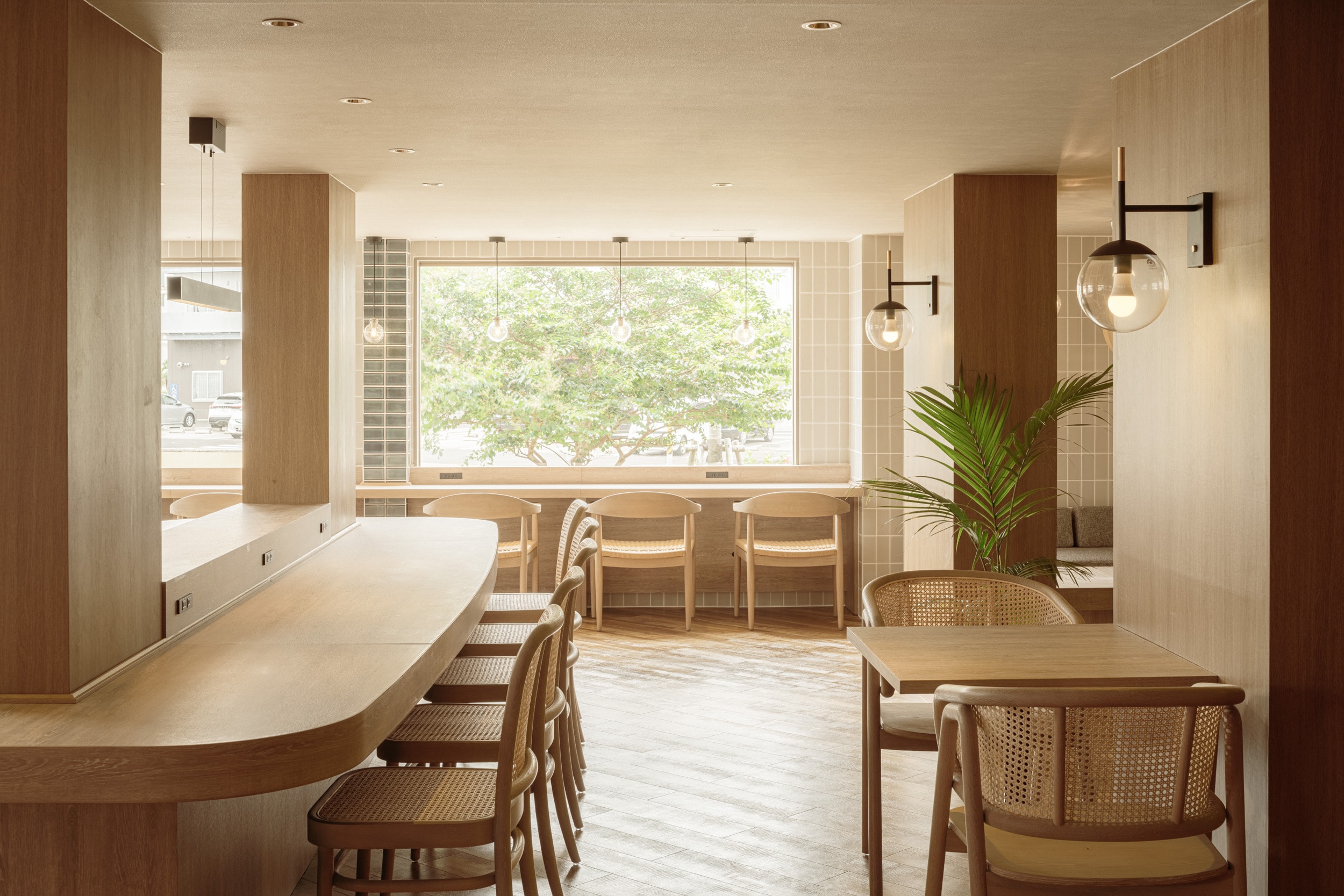 The lobby is filled with warm sunlight through the large windows.