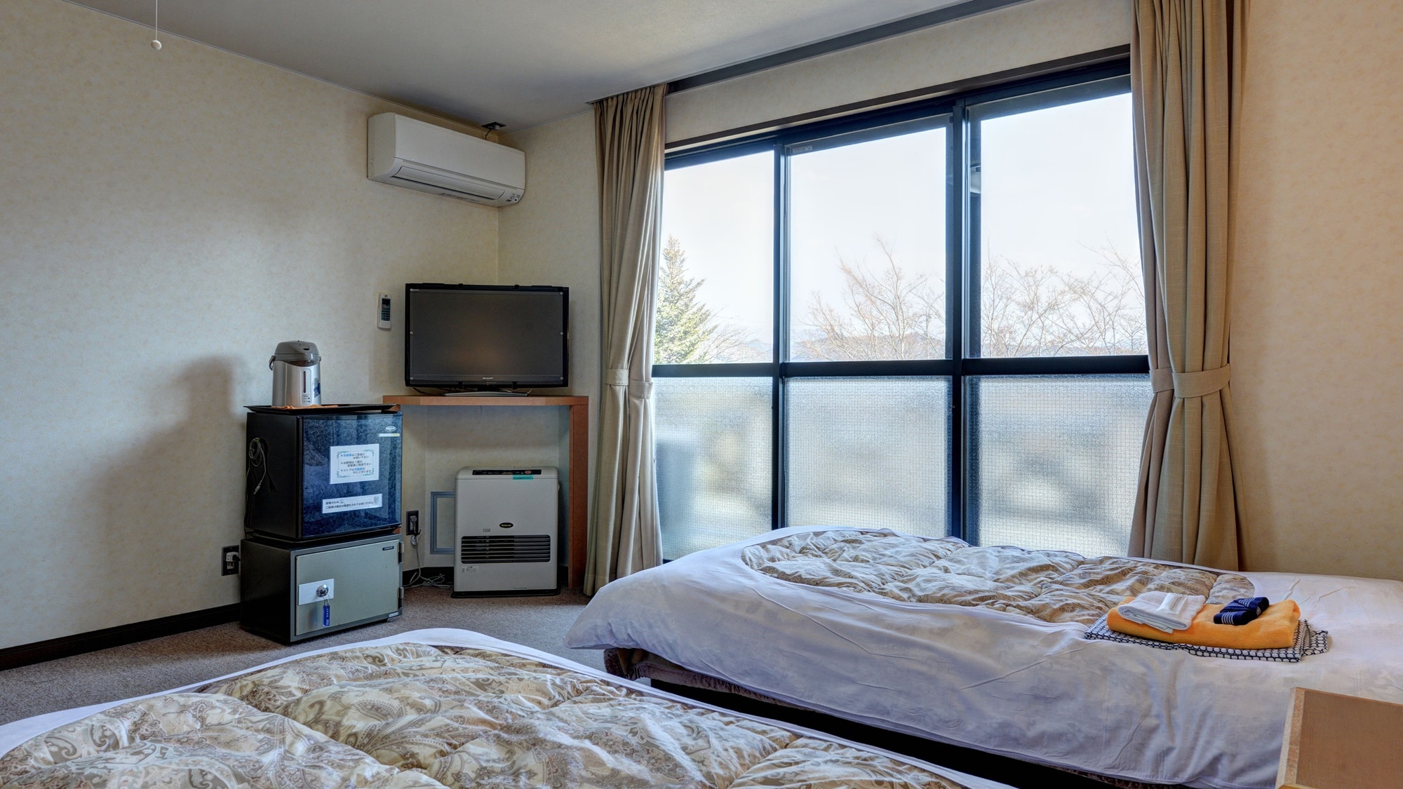 * [2nd floor twin room with unit bath] A spacious room with a desk separate from the table and sofa.