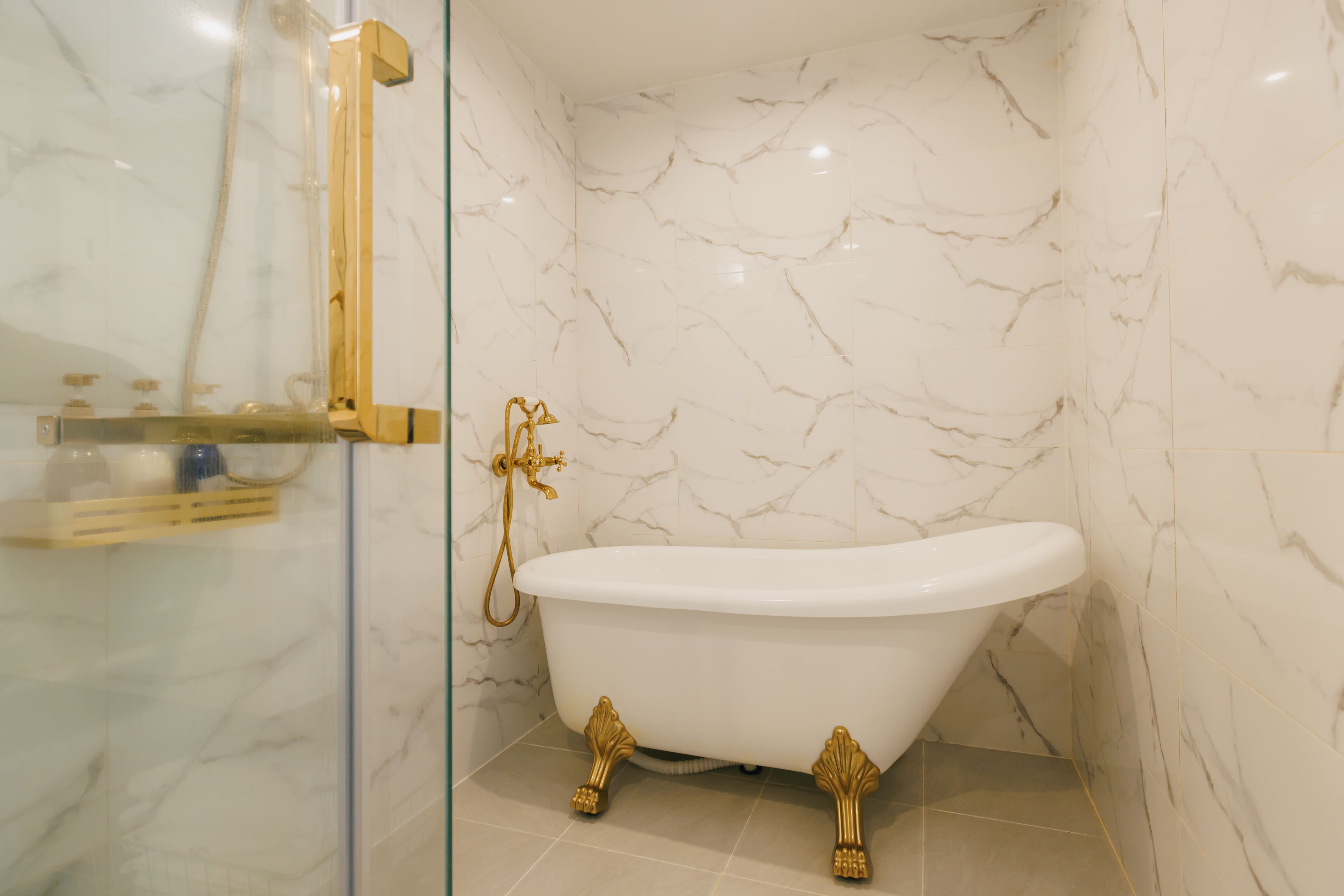 The simple and open bathroom features a stylish clawfoot bathtub.