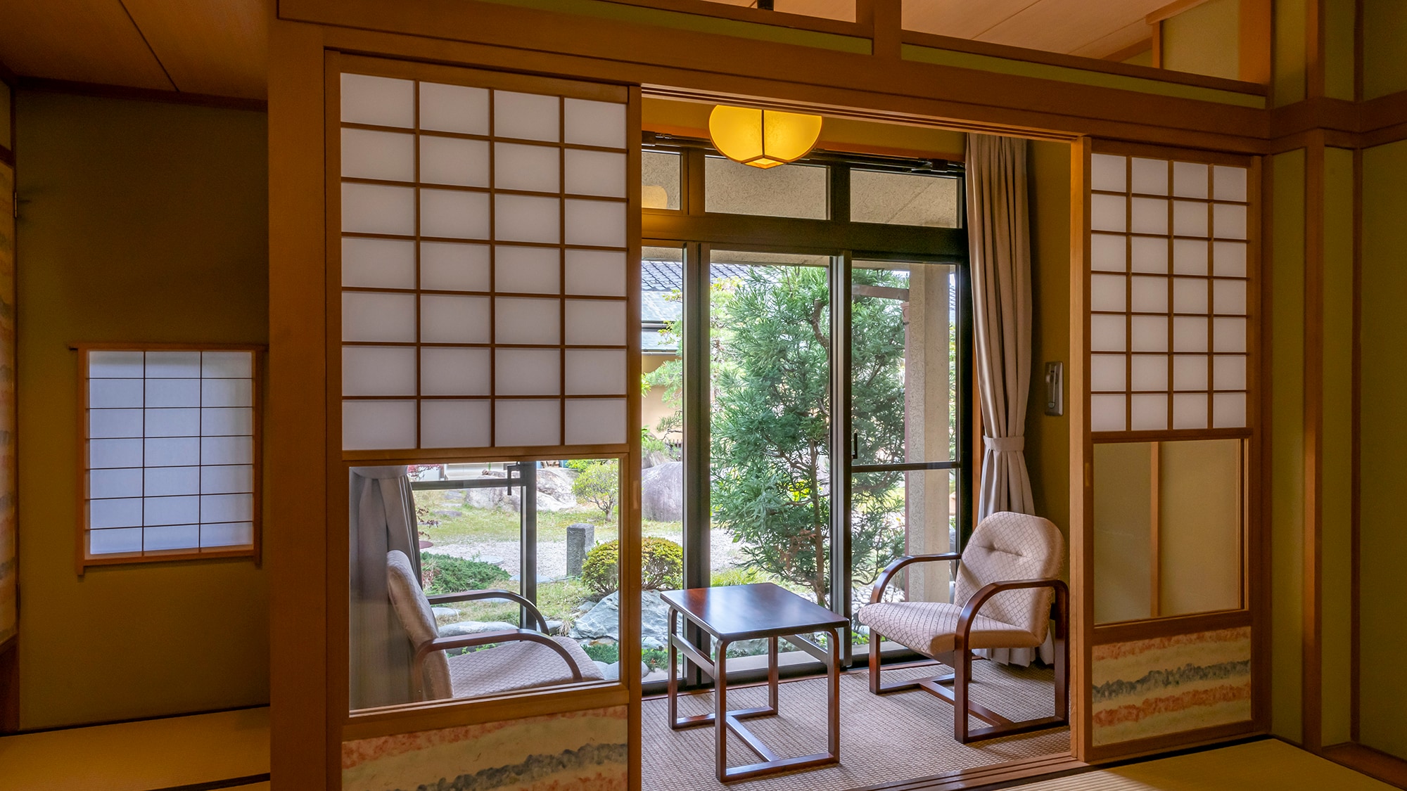 <Guest room with garden> The spacious room layout features chairs and a table on the veranda.