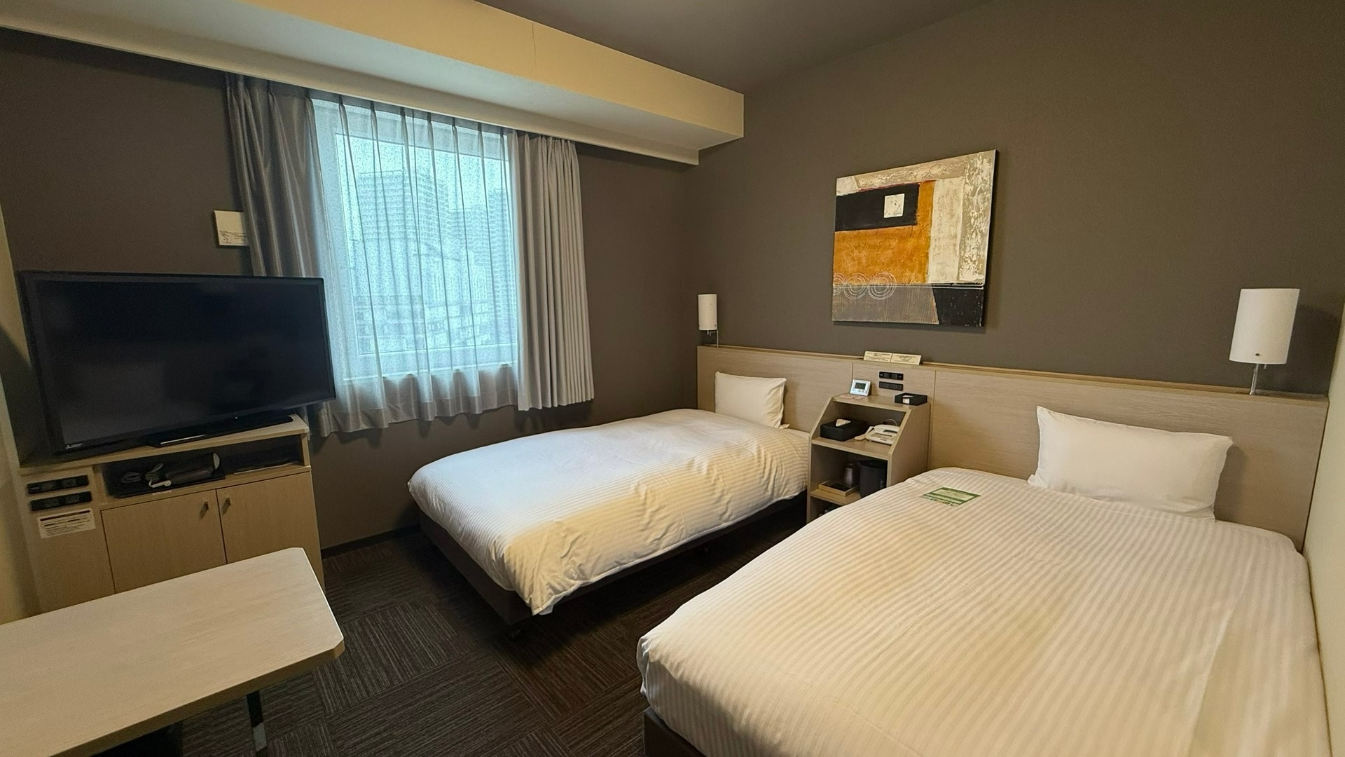 標準雙床房（床尺寸 110 x 200 公分），配有加濕空氣清淨機和床邊電源插座。