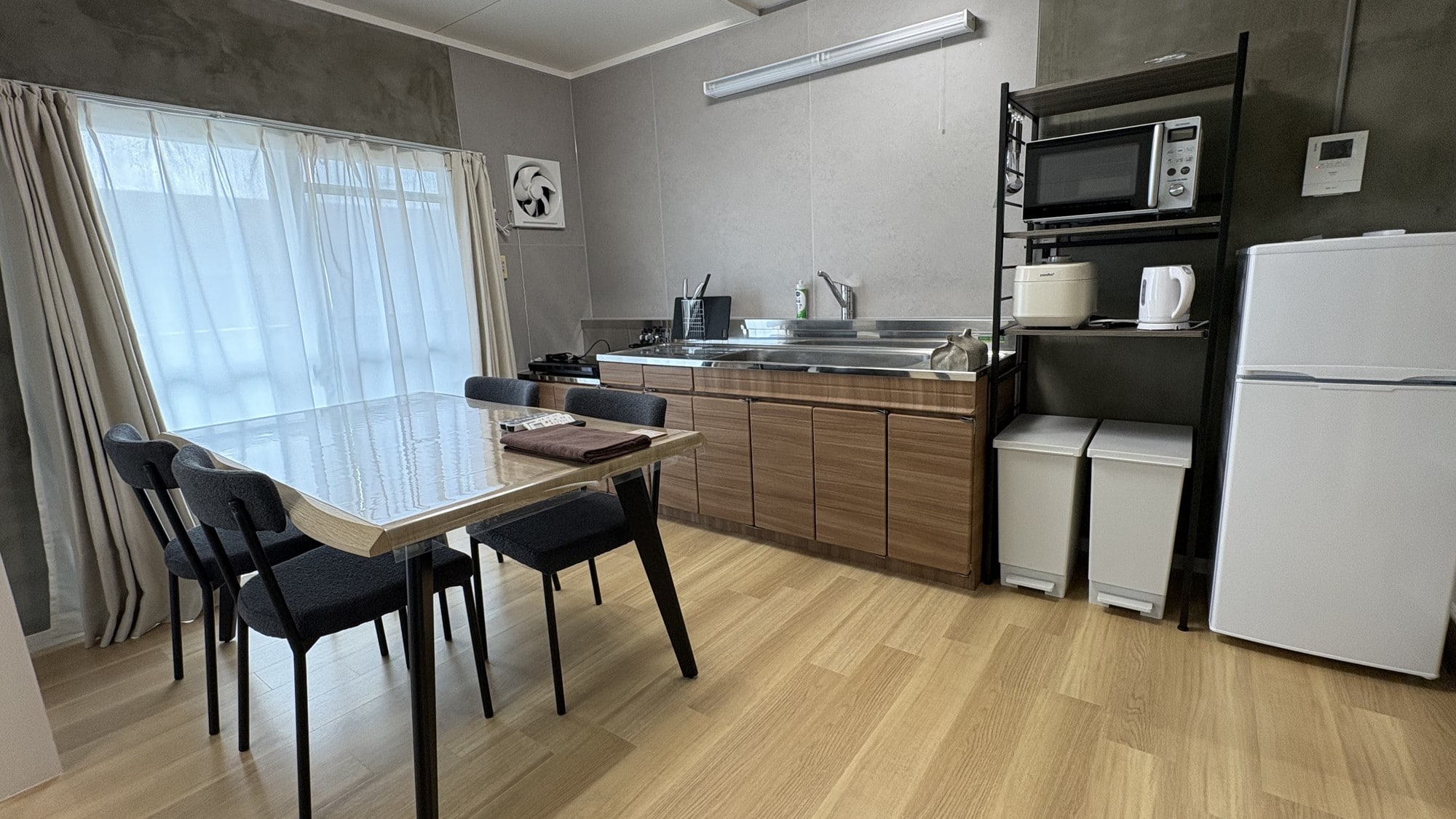 The kitchen is fully equipped with a refrigerator, microwave, rice cooker, and other amenities.
