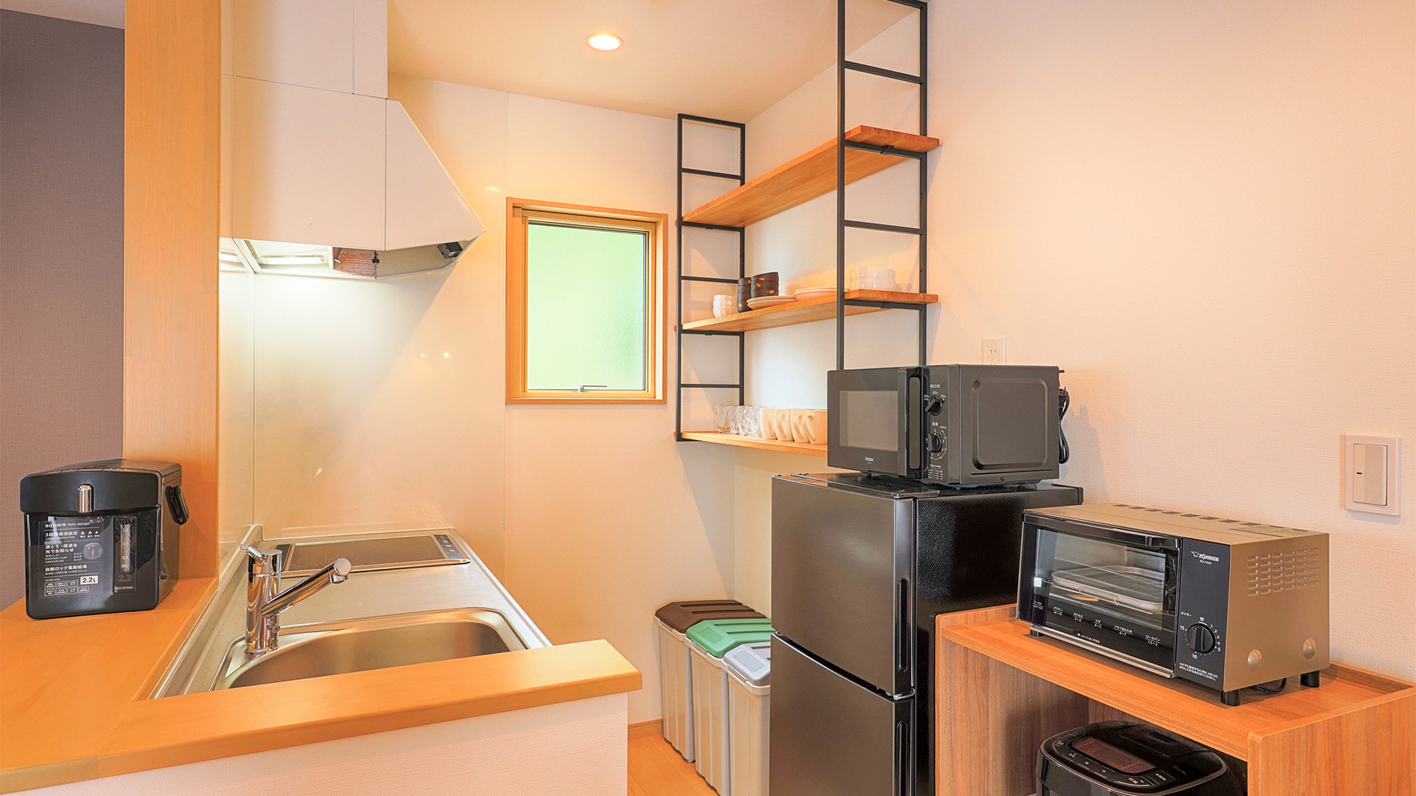 ・The kitchen is equipped with an induction stove, refrigerator, and cooking utensils.