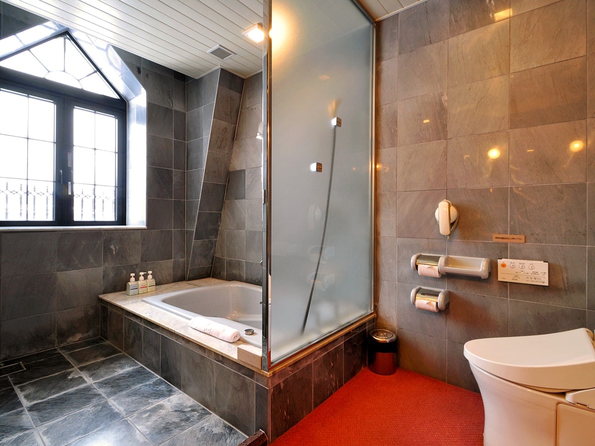 [Deluxe Twin] The well-lit bathroom is luxuriously constructed.