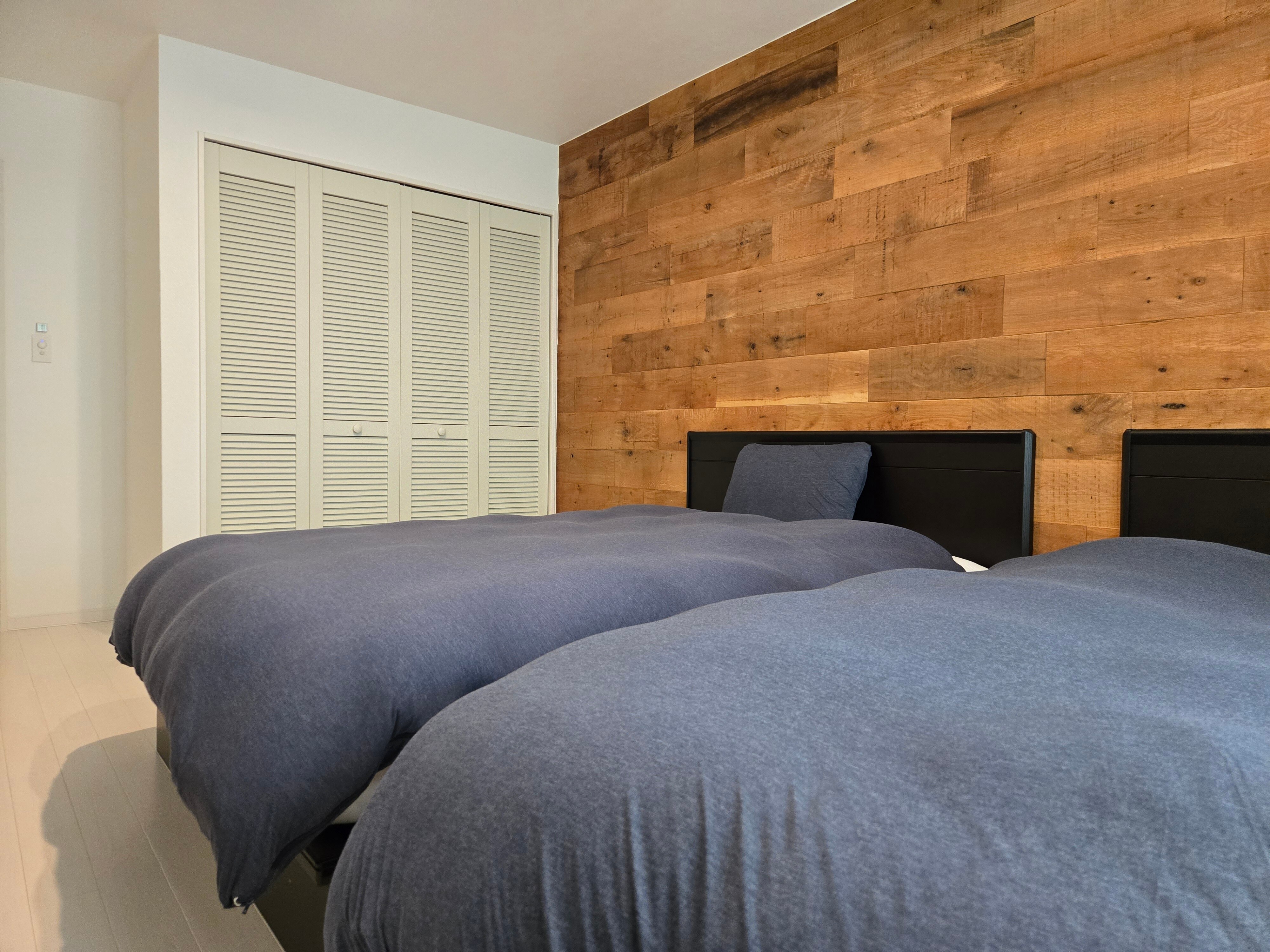 A tranquil bedroom with a wood accent wall.