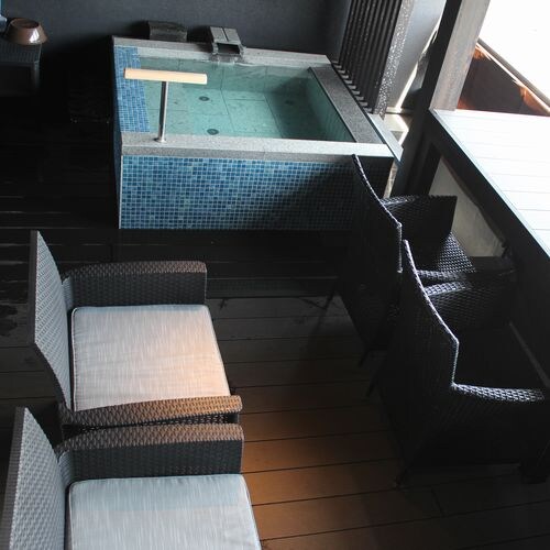 The terrace is equipped with an open-air bath and chairs.