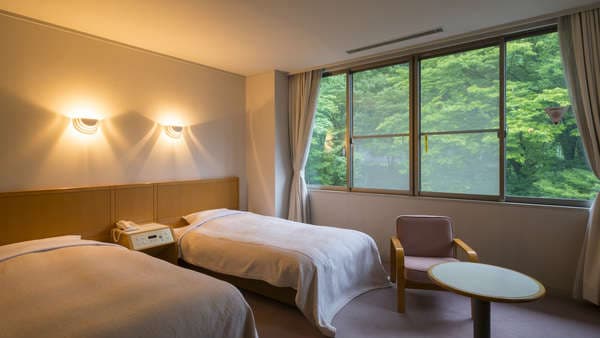 [Quiet Western-style room with twin beds facing the mountains]