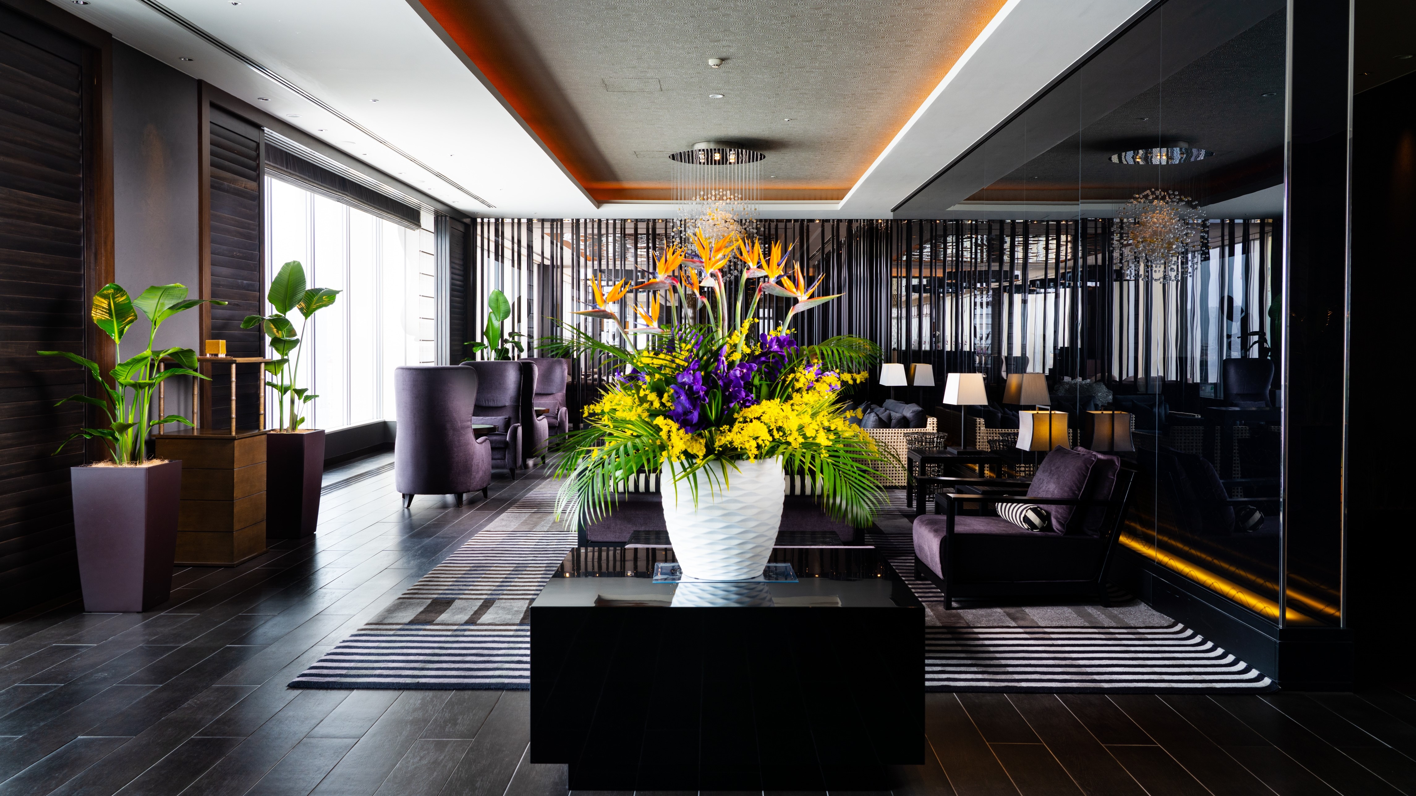 The lobby on the top floor overlooking the city of Naha and the harbor is greeted by colorful lobby flowers.