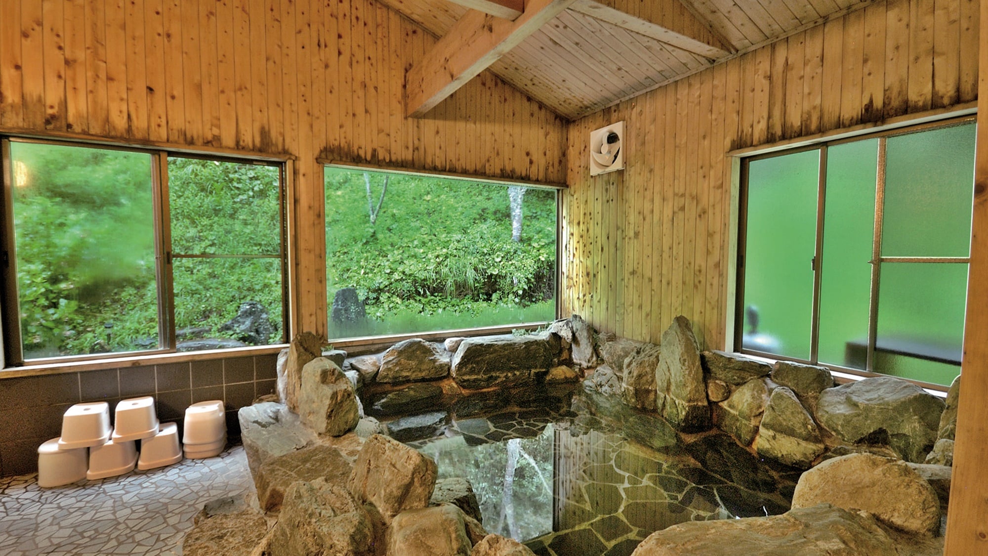 *[Rock bath] A rustic rock bath in a cypress bathroom. Nature is right in front of you, so close you can reach out and touch it.