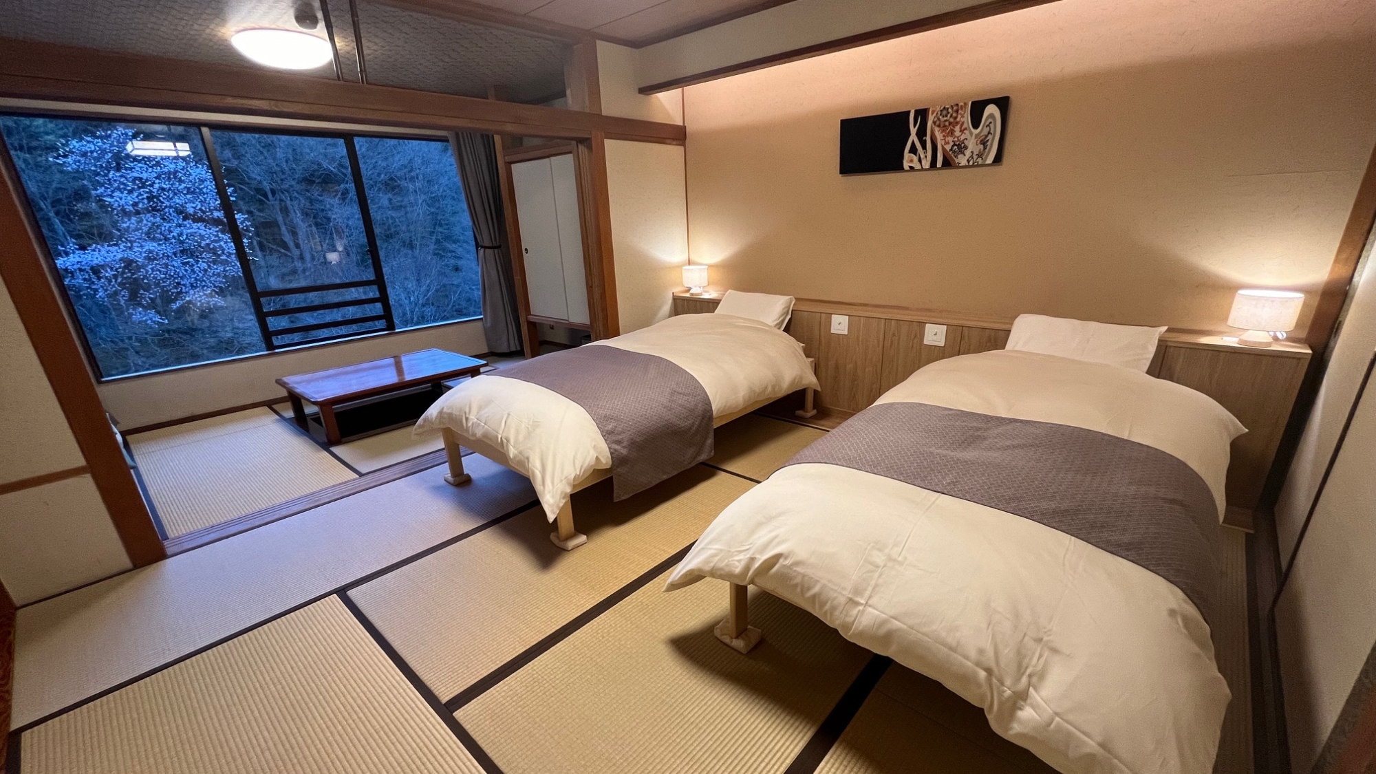A Japanese-style twin room with 8 tatami mats and a sunken kotatsu table overlooking Mt. Tanigawa (example)