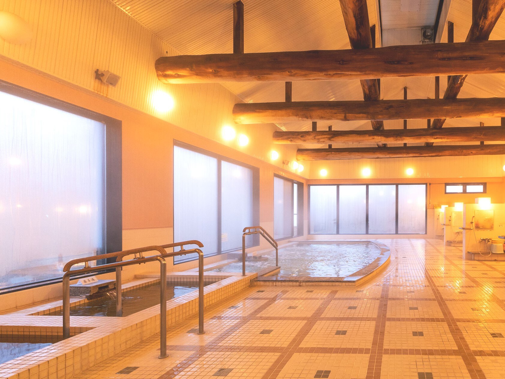 [Large public bath]. Both the men's and women's baths feature thick beams and are equipped with three types of bathtubs and a sauna.
