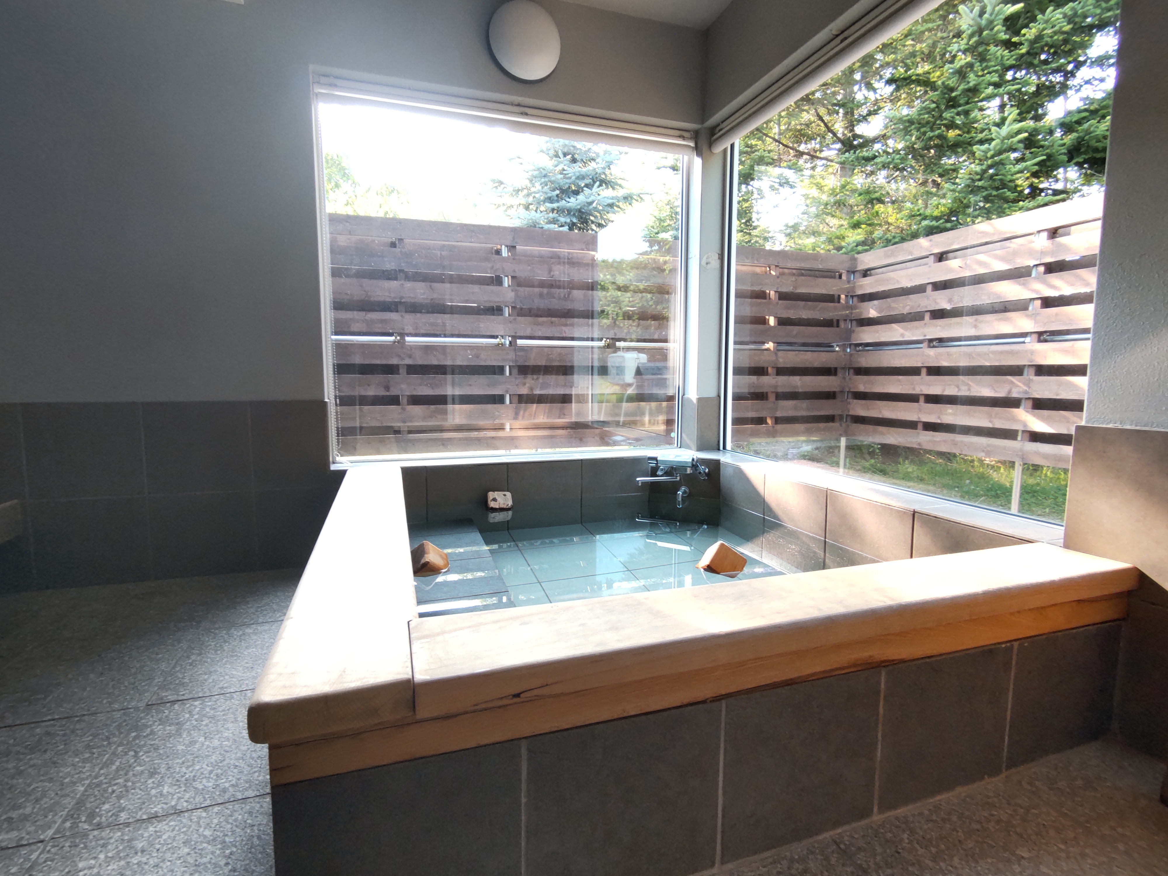 The large windowed bath is relaxing with the scent of Japanese cypress. It is available for private use for each guest.